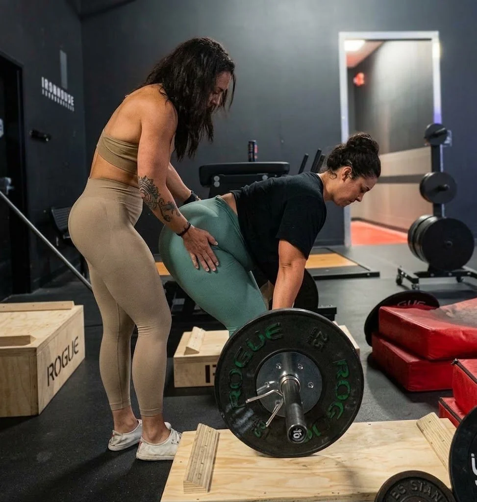 Amber coaching a client through a deadlift at Iron House Gym
