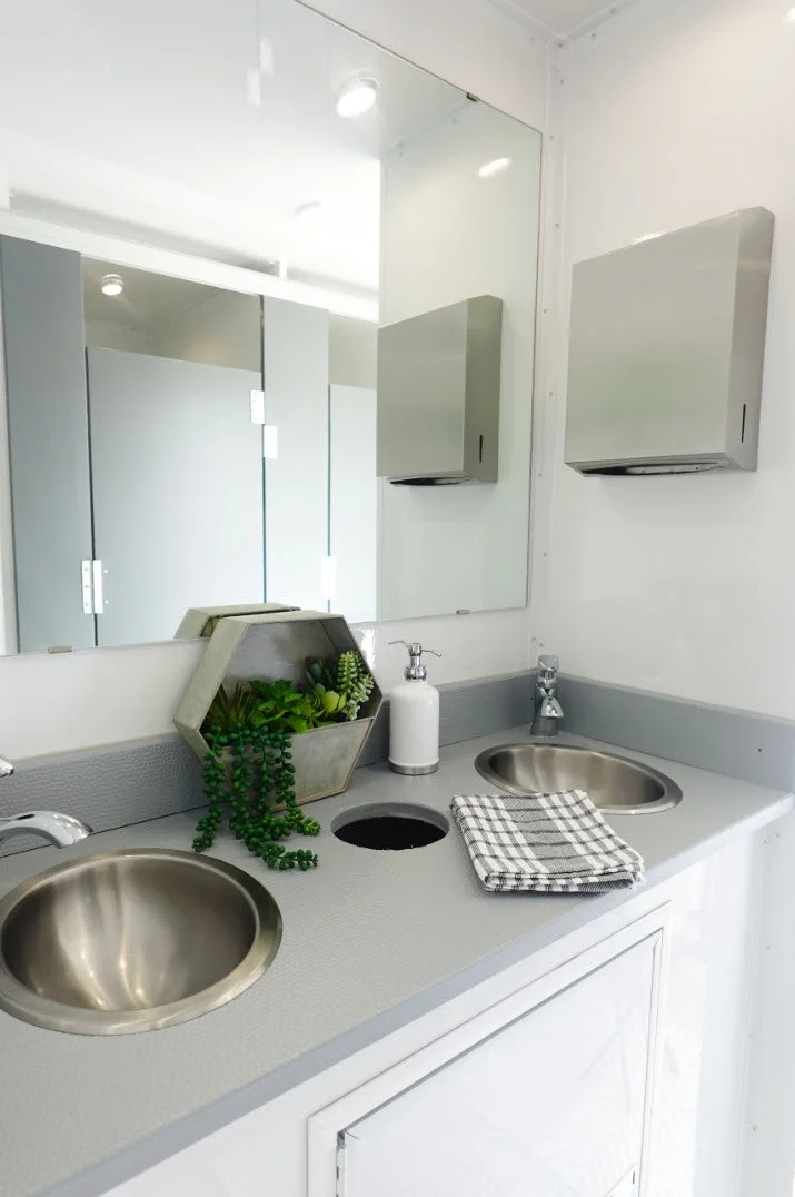 Luxury restroom trailer vanity with sink, mirror, and countertop amenities