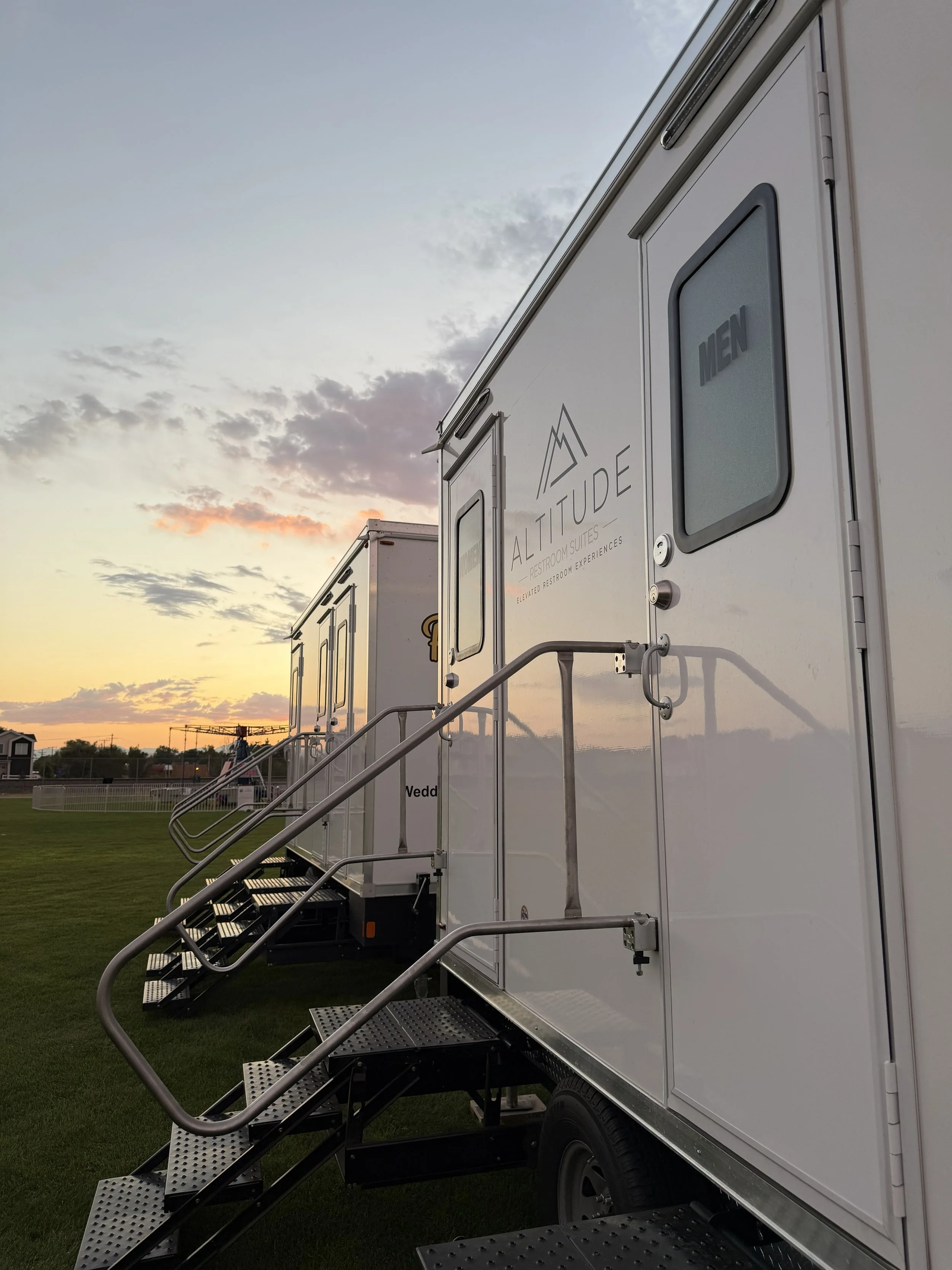 Luxury restroom trailer by Altitude Restroom Suites at a Colorado outdoor event during sunset