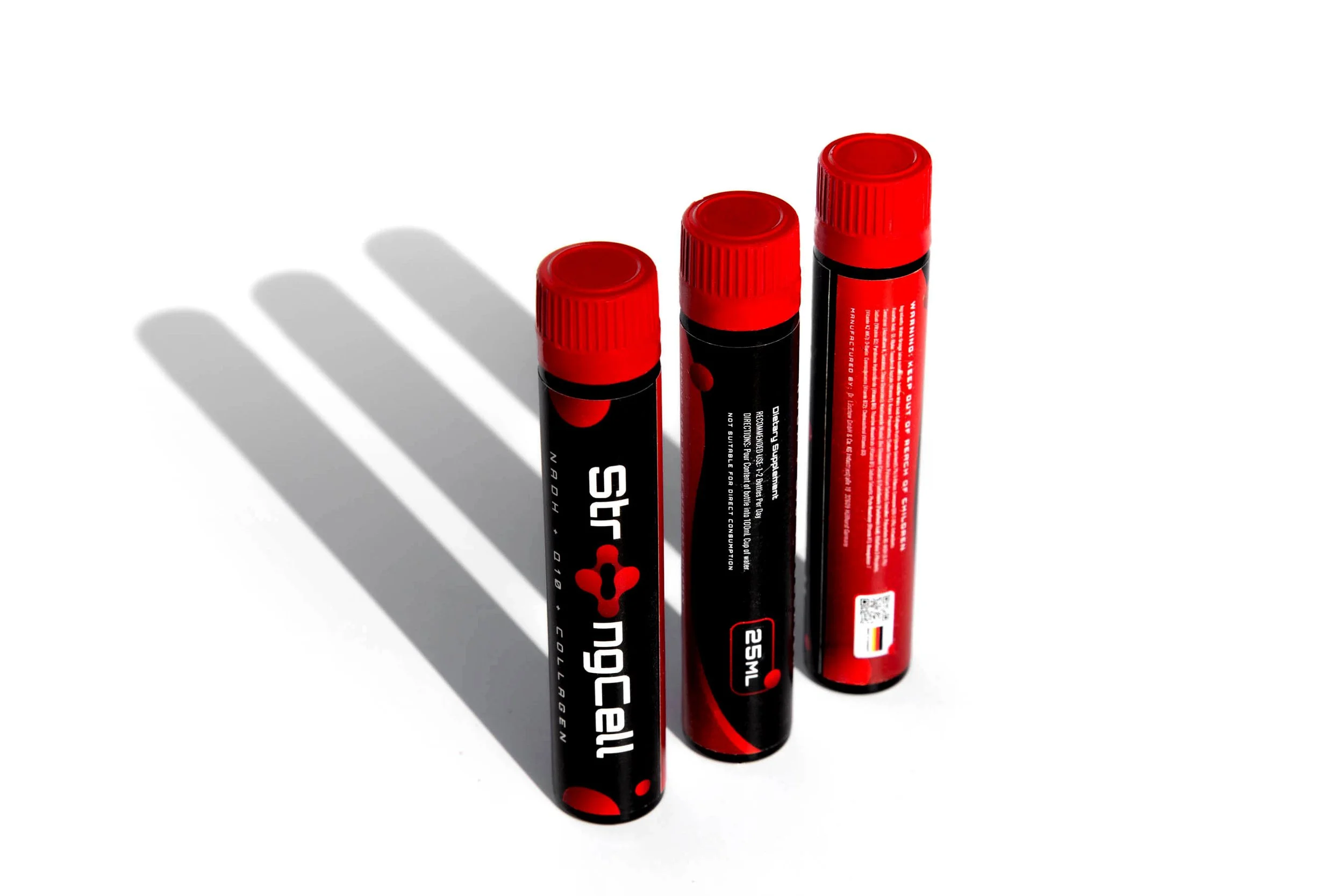 Three black and red marker tubes with red caps and shadows cast on a white surface.