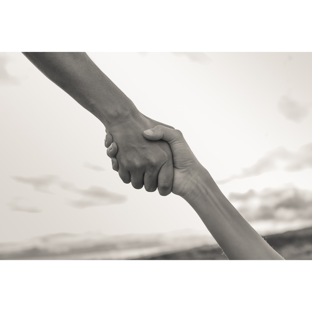 Two people shaking hands outdoors with a cloudy sky in the background, symbolizing unity or cooperation.