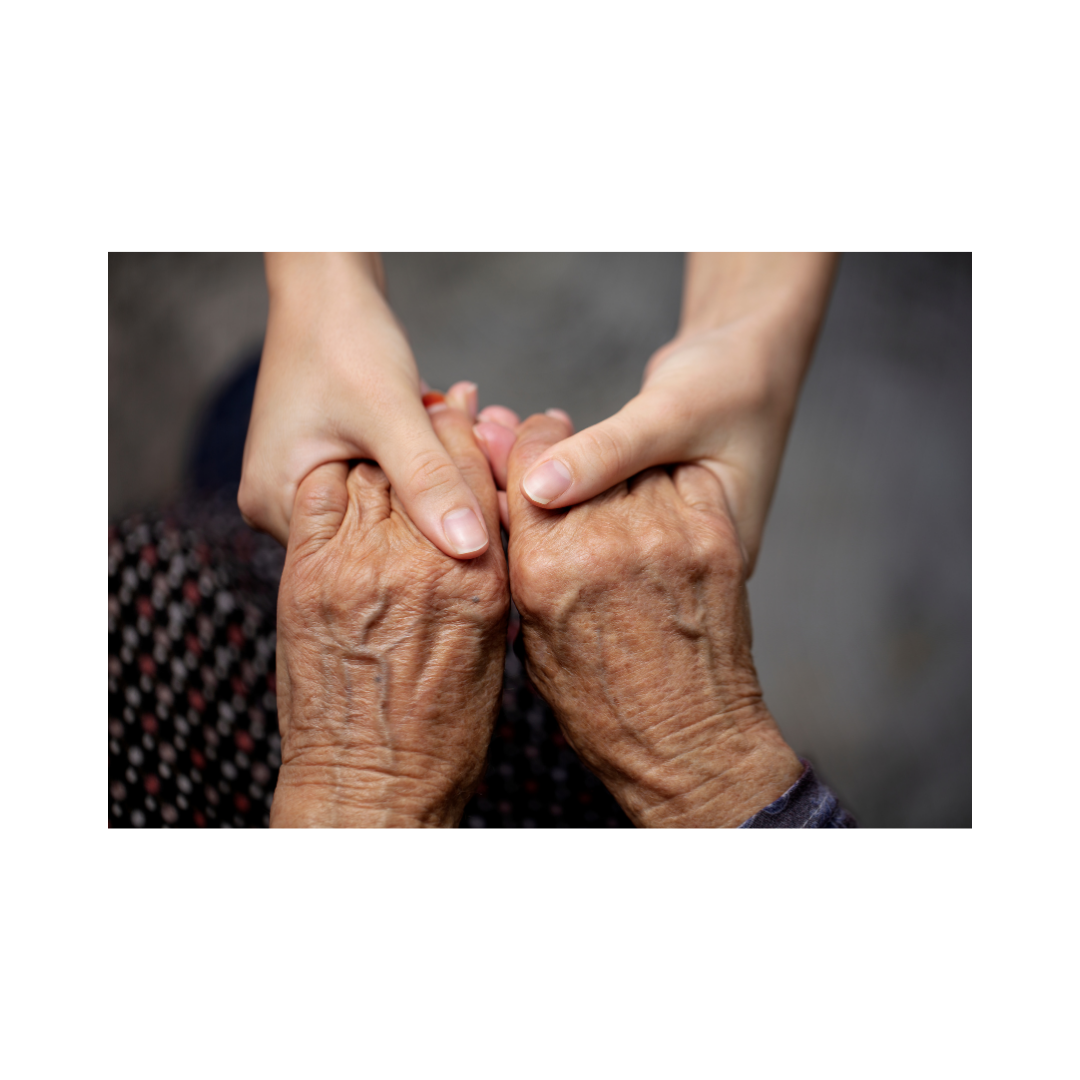 Young person's hands holding the wrinkled hands of an elderly person.