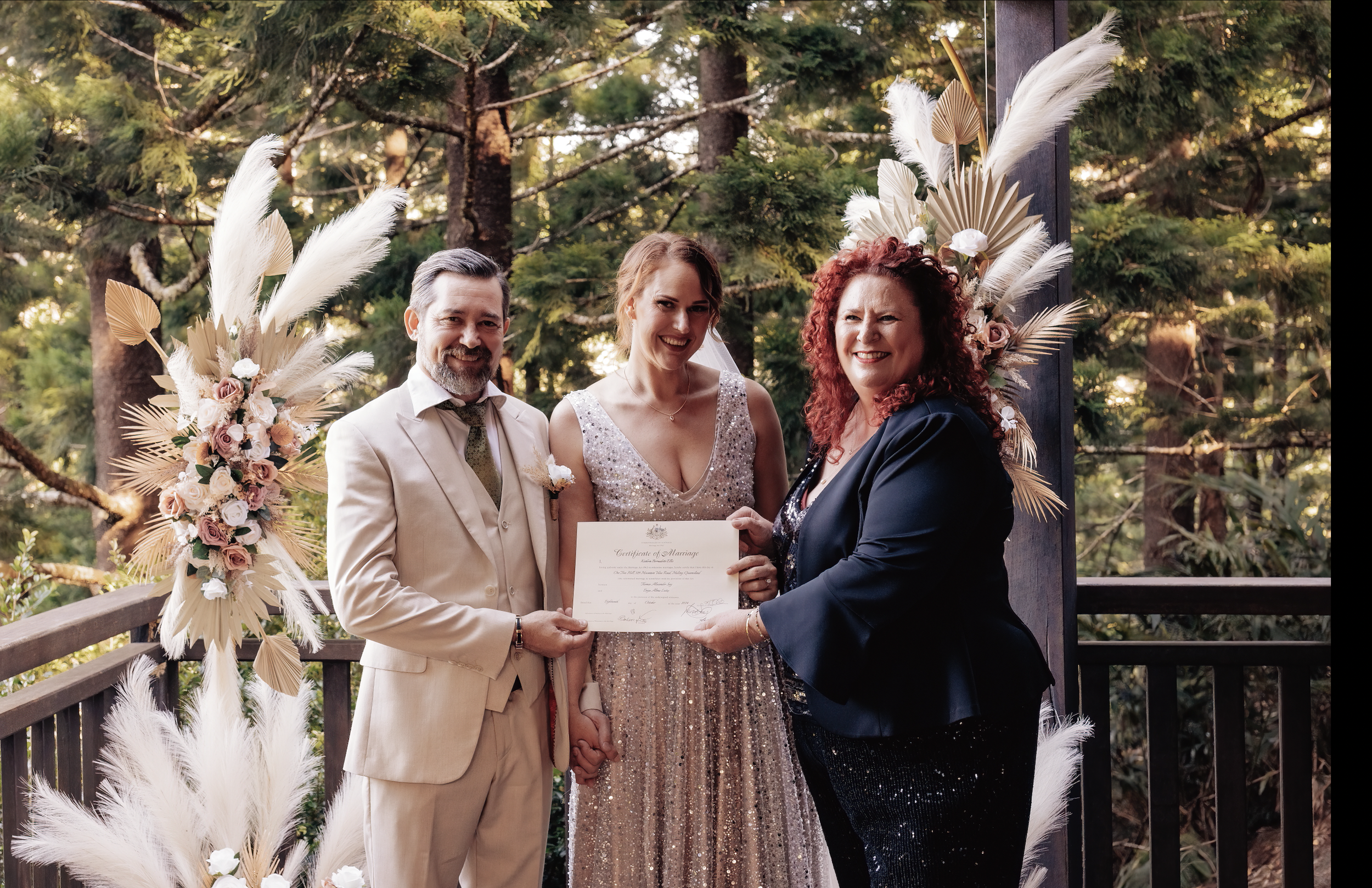 Kate Ellis, marriage celebrant, smiling warmly with a couple at their wedding ceremony on the Sunshine Coast