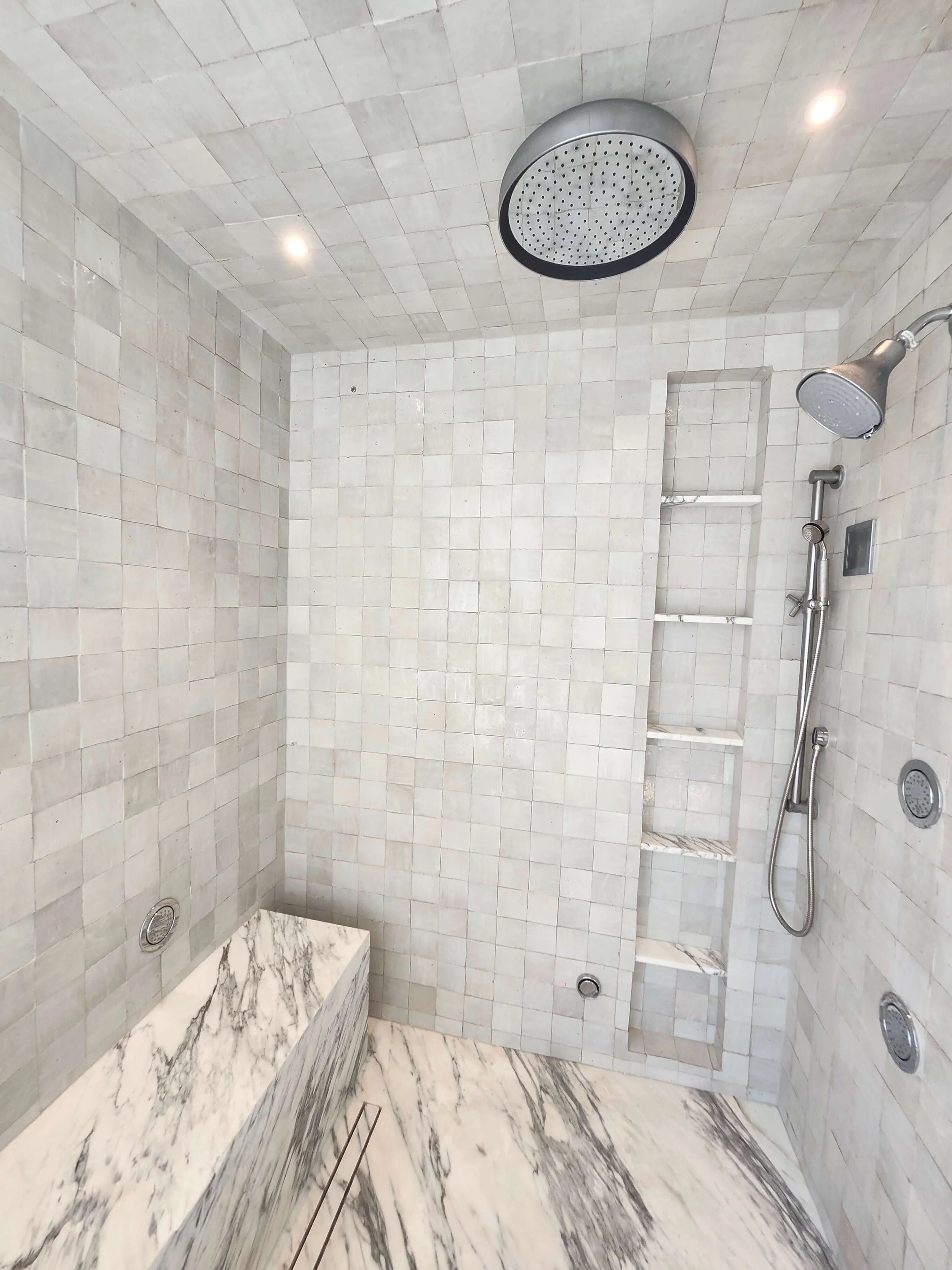 Large shower with granite tile. Large granite bench. Chrome