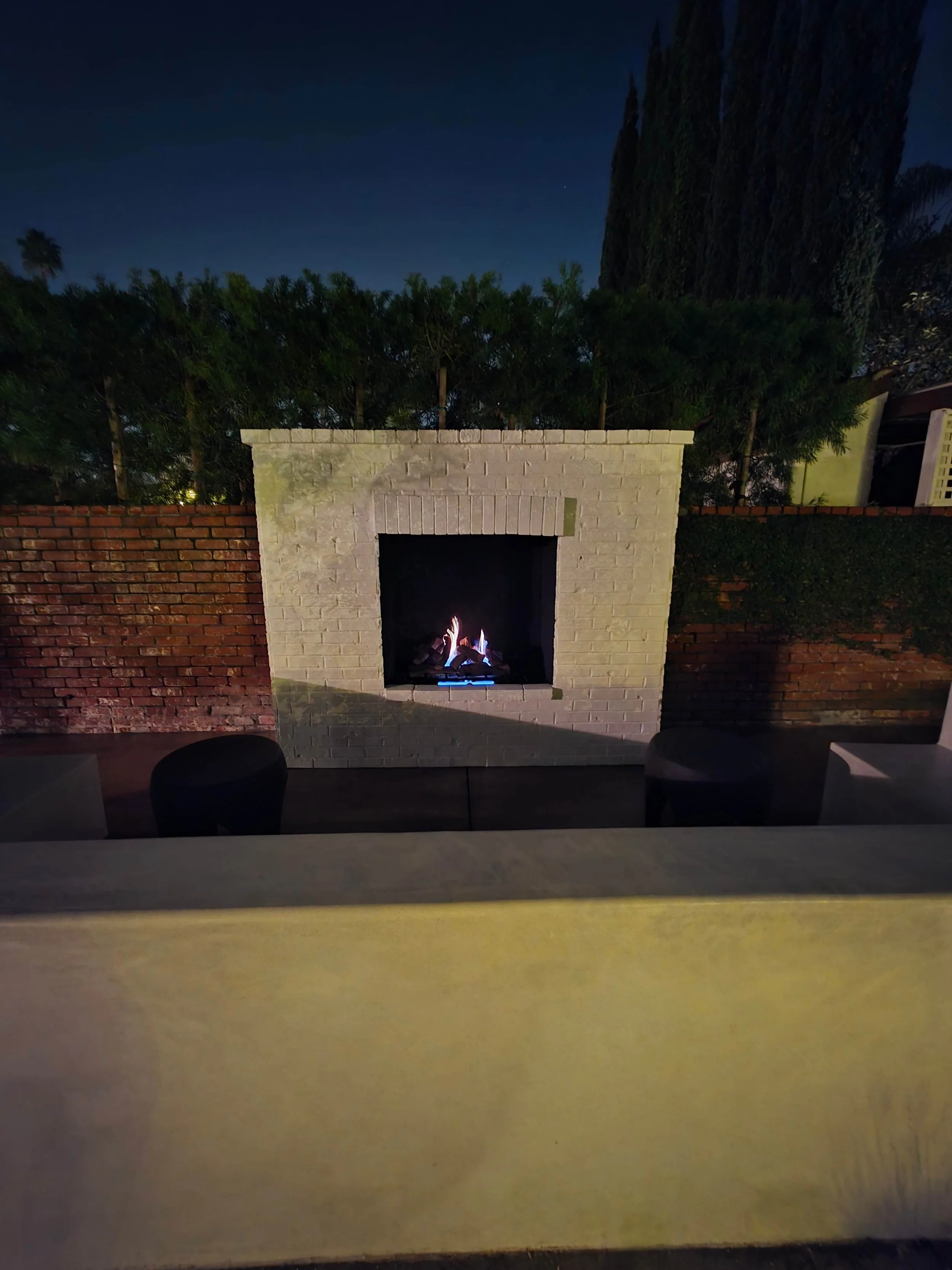 refinished outdoor brick fireplace and stucco and concrete bench