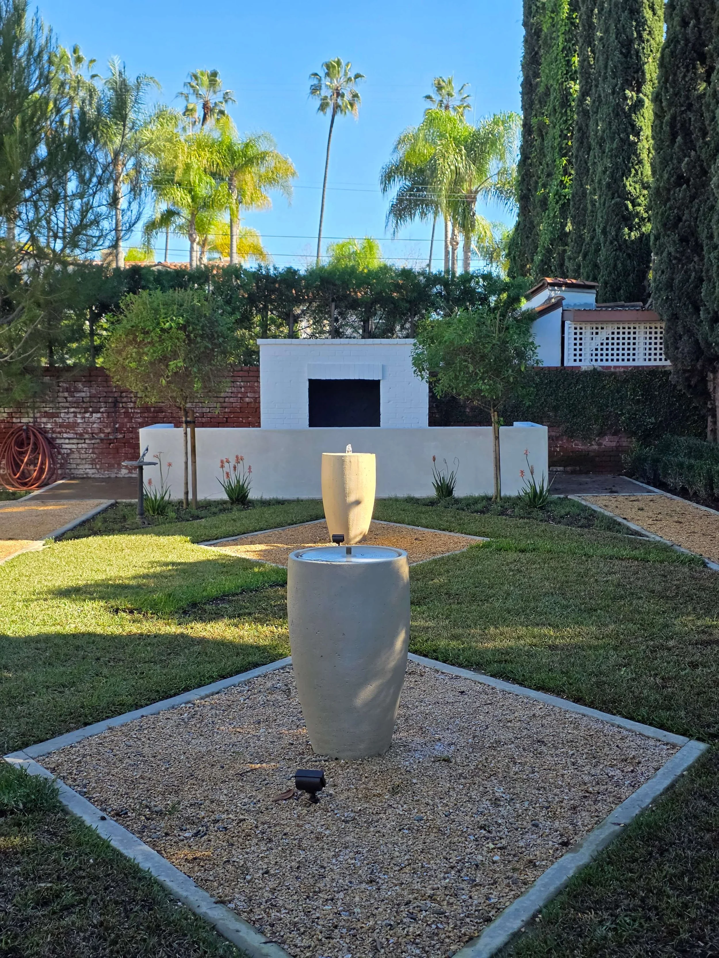 Luxury outdoor fire pit made with stucco and brick including bench in Los Angeles