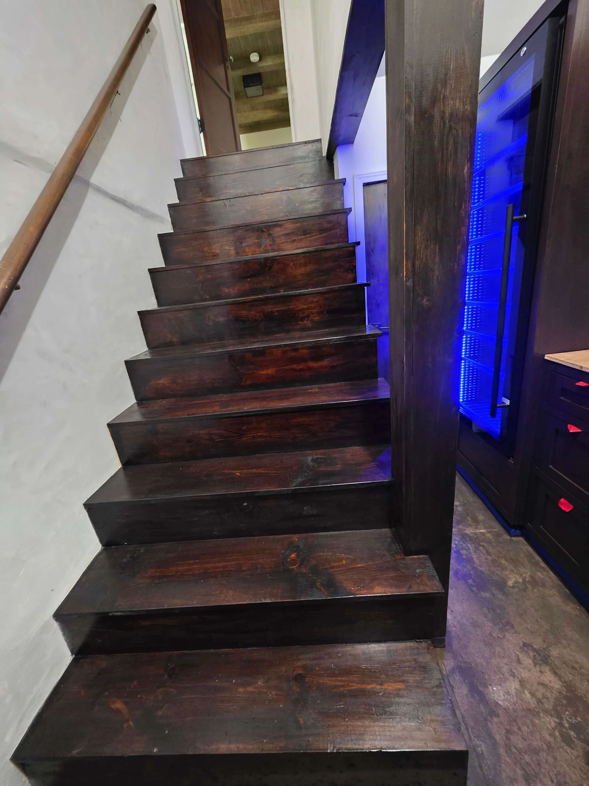 Custom wine cellar. Dark wood staircase and risers