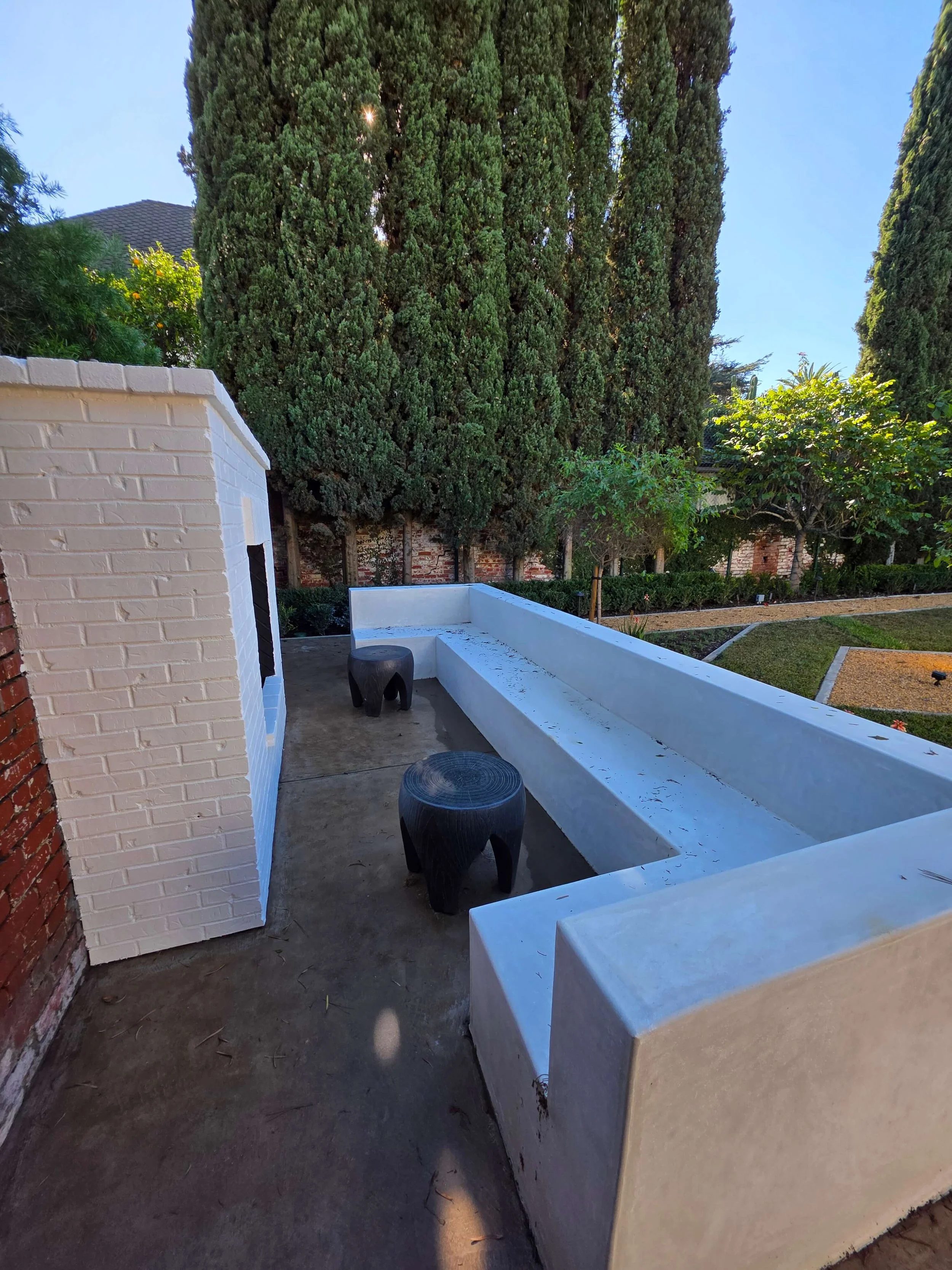 Custom concrete and stucco outdoor bench for enjoying fireplace