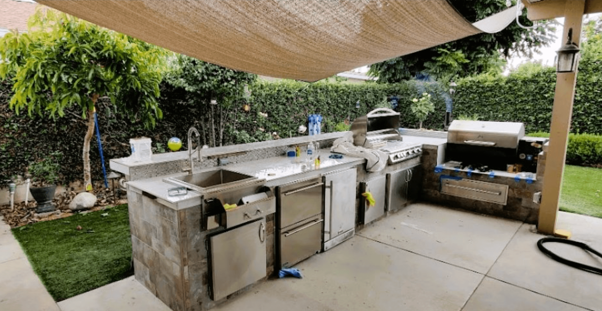 Outdoor kitchen. Stainless steel and granite counters. Grill. Sink. Fridge