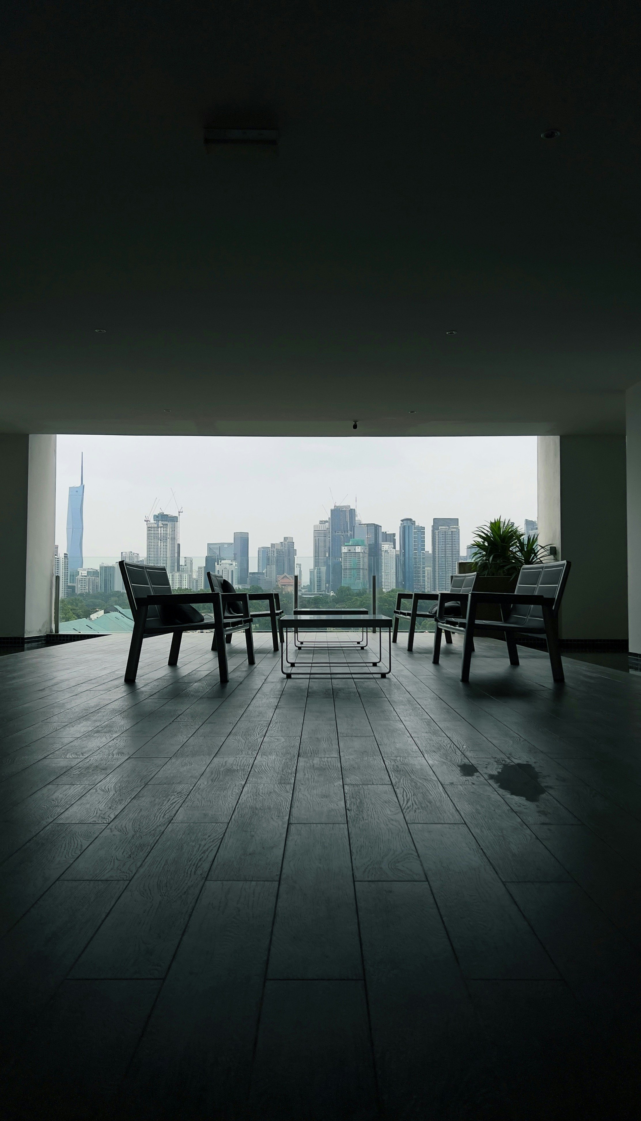 Two pairs of chairs facing each other in a quiet room that opens onto a city skyline