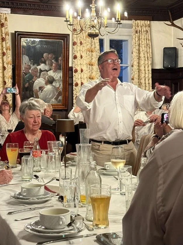 Kerry leading a song at dinner in Austria