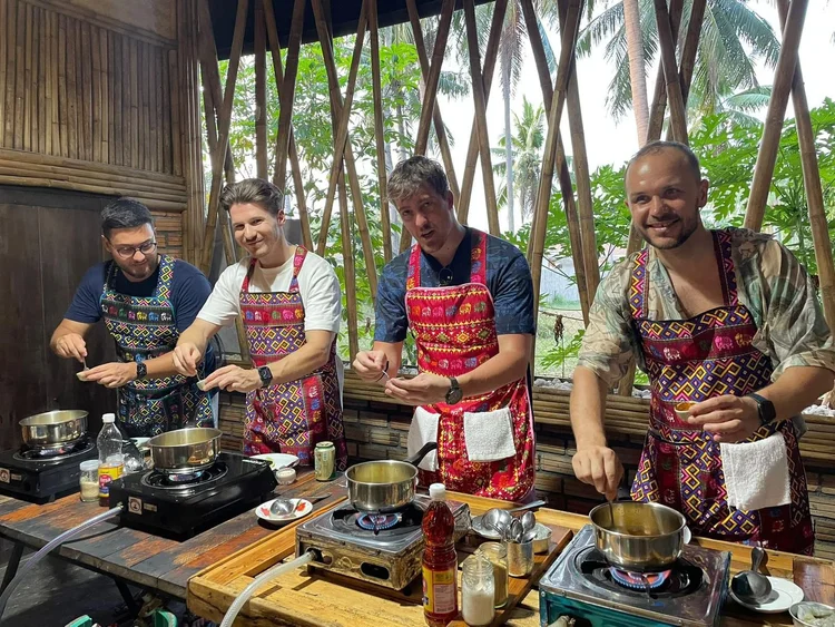 Students cooking together in the open-air kitchen at Proud Home