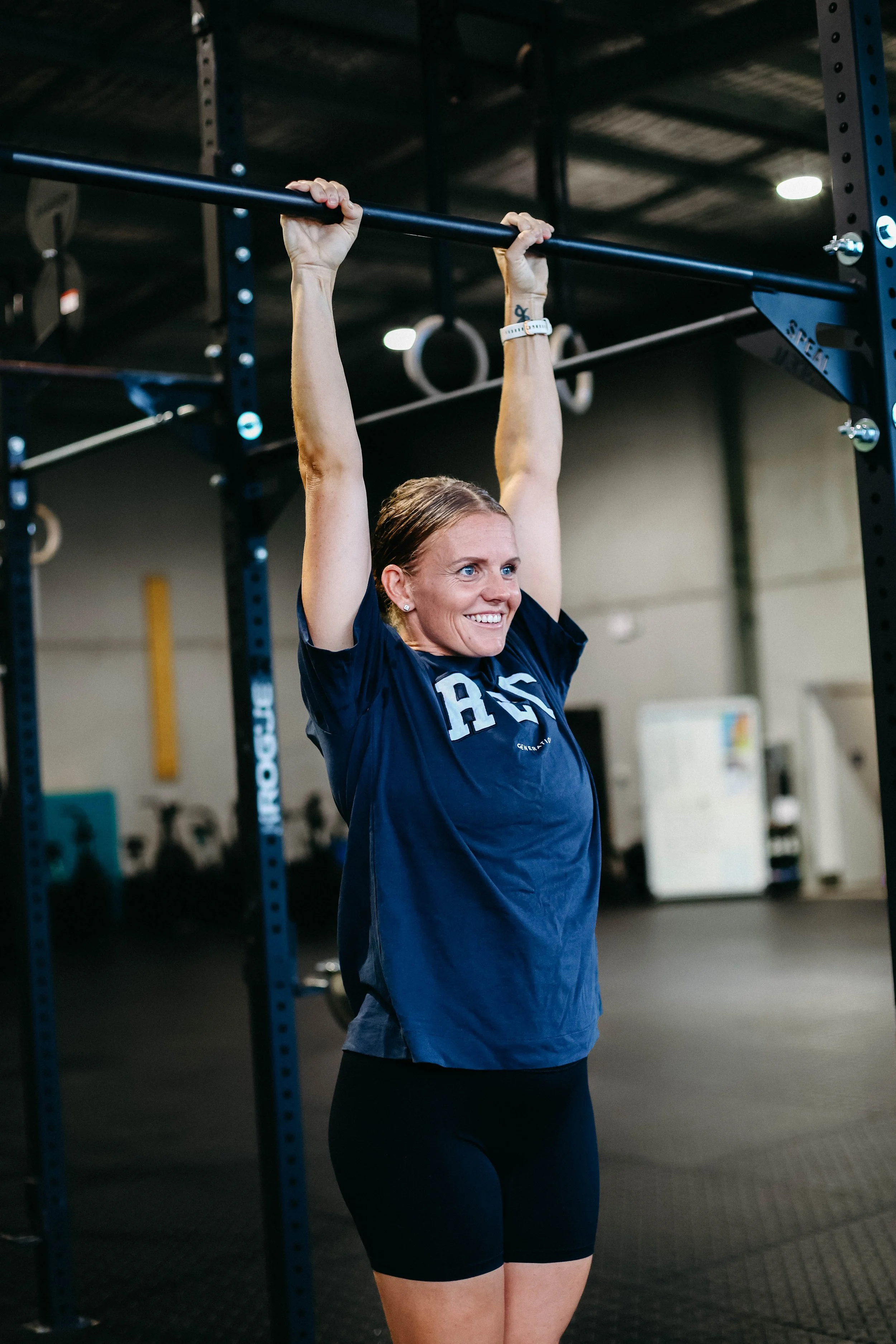 Katelyn hanging from a pull up bar