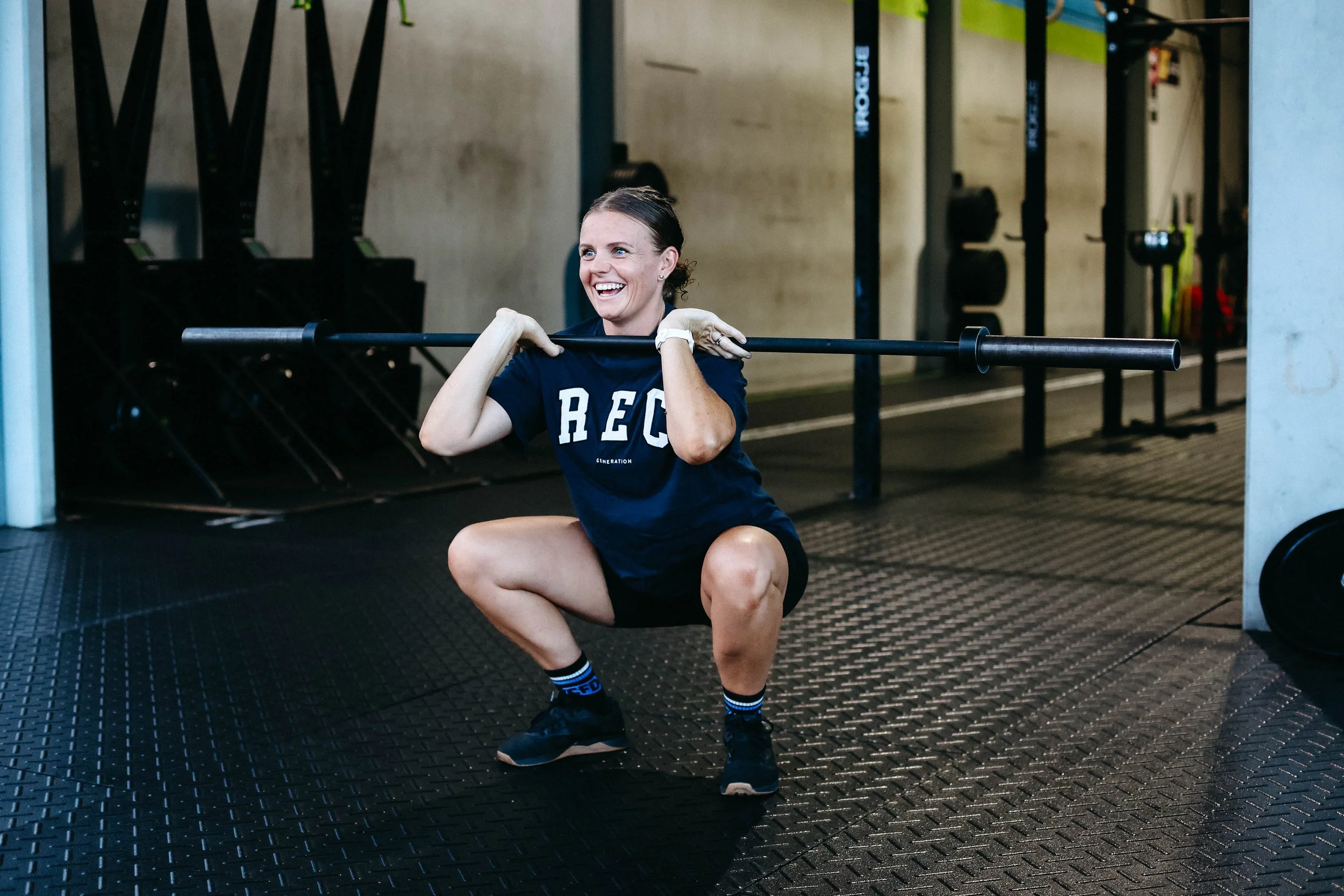 Katelyn warming up a squat clean with an empty barbell.