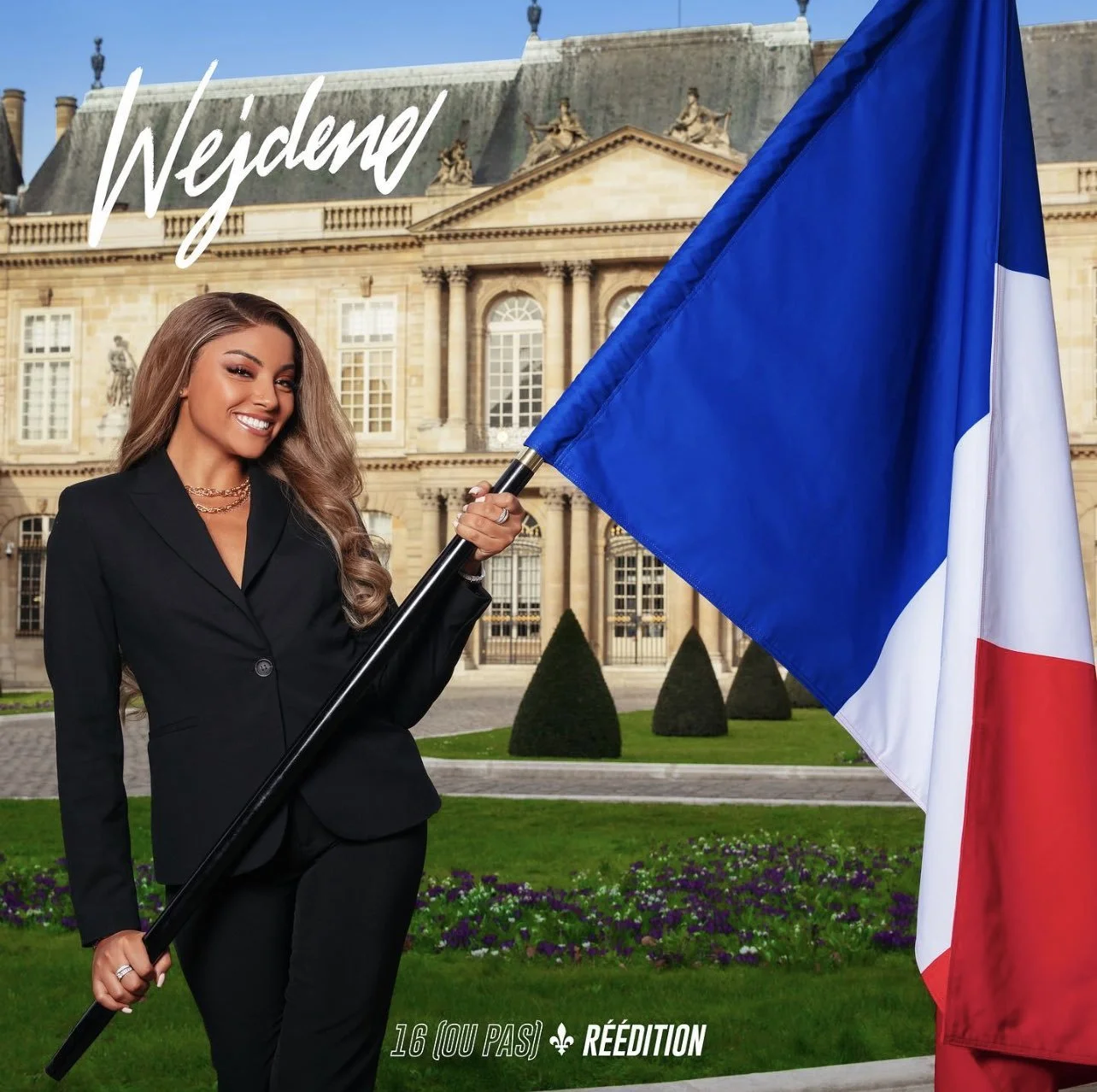 Une femme souriante en costume noir tient un drapeau français devant un bâtiment historique en pierre avec des jardins en premier plan. Le texte sur l'image est 'Wejdene' en haut à gauche et '16 [ou pas] réédition' en bas.