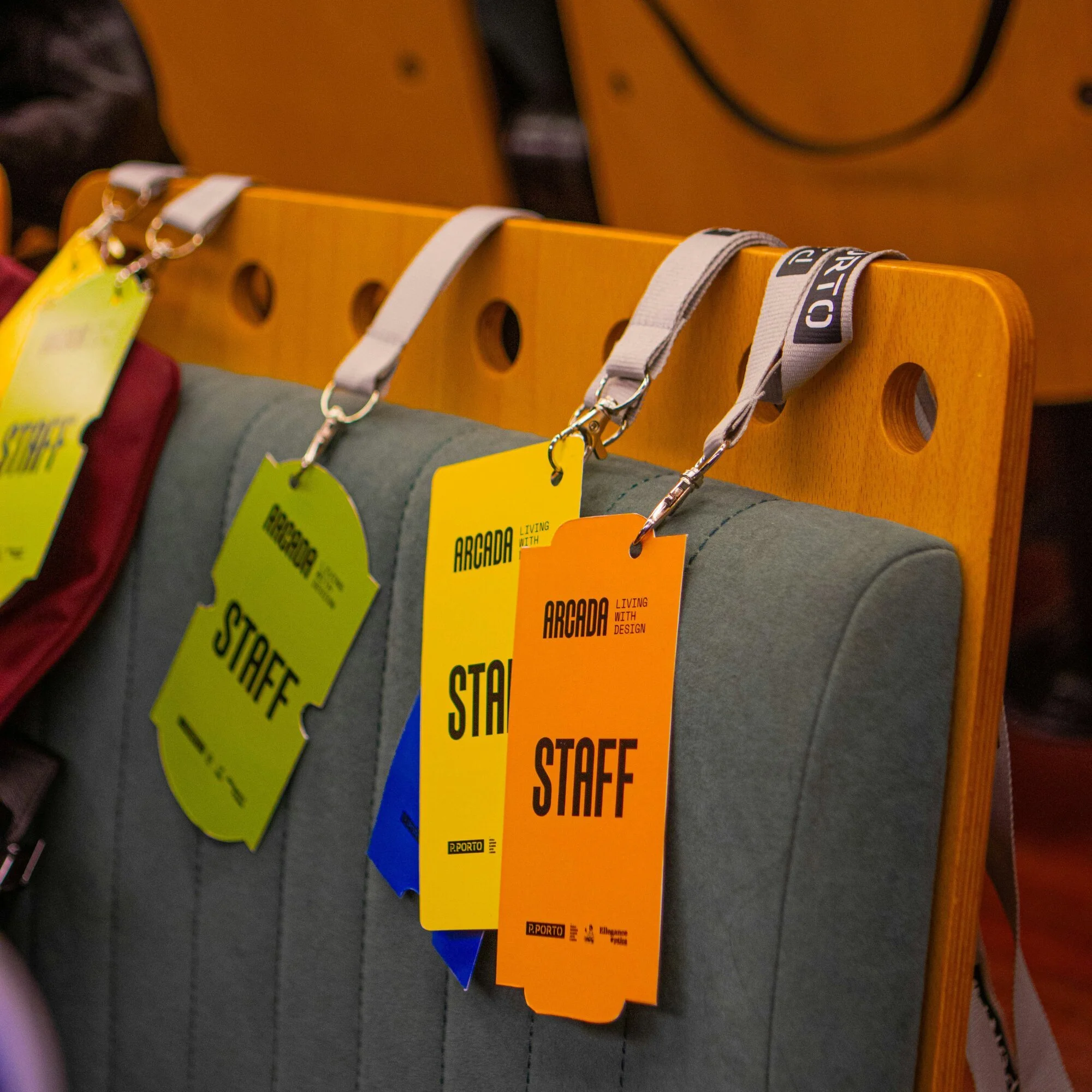 Colorful lanyards hanging on an orange display board in a store.