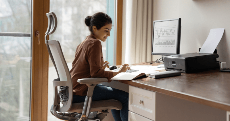 person looking happy, working at a computer with uncluttered workspace