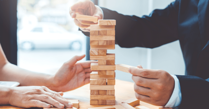 business leaders playing jenga