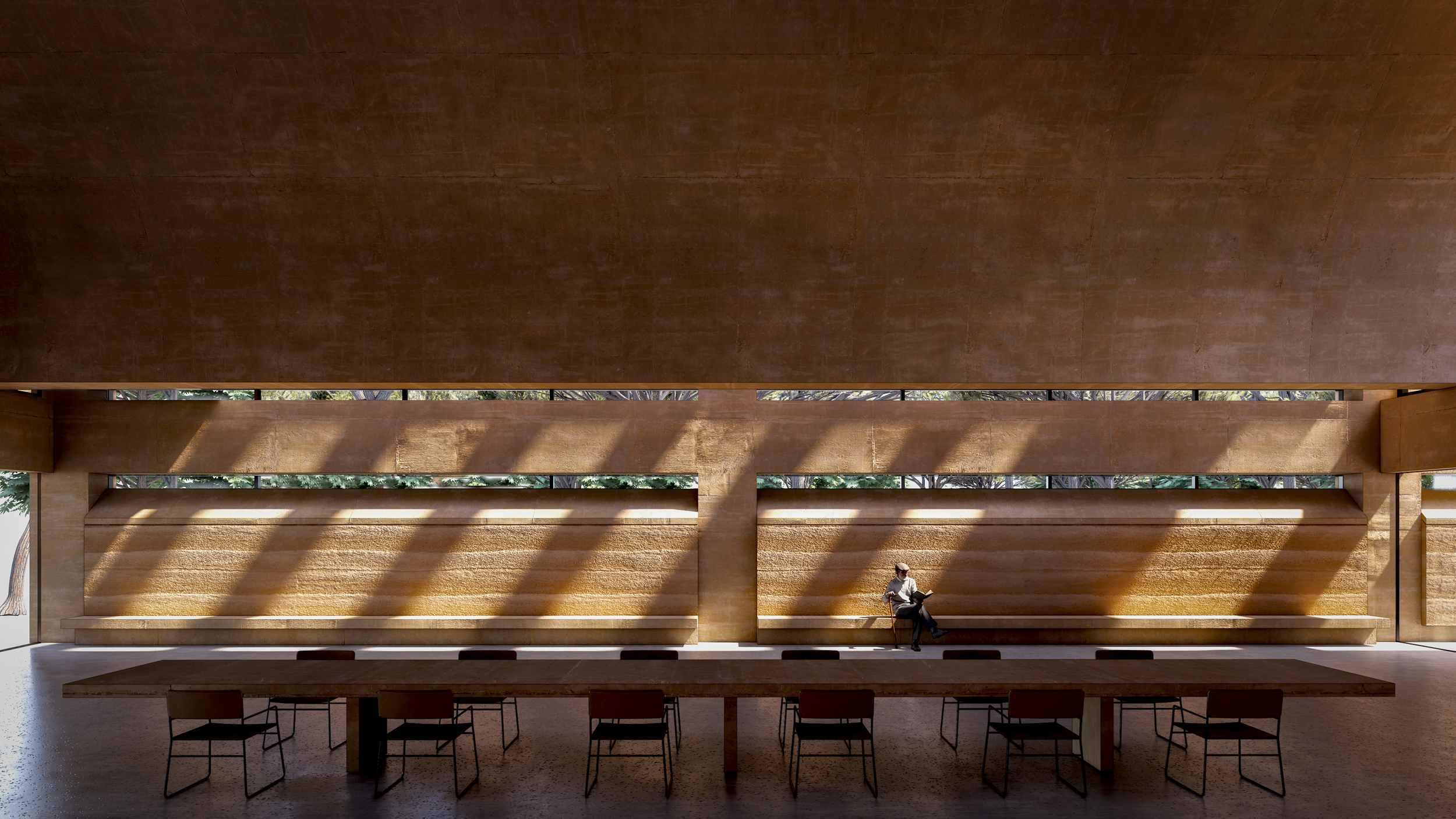 Interior of a modern building with high ceiling, large horizontal windows, and beige brick walls; a man sitting on a bench appears to be reading or using a device.
