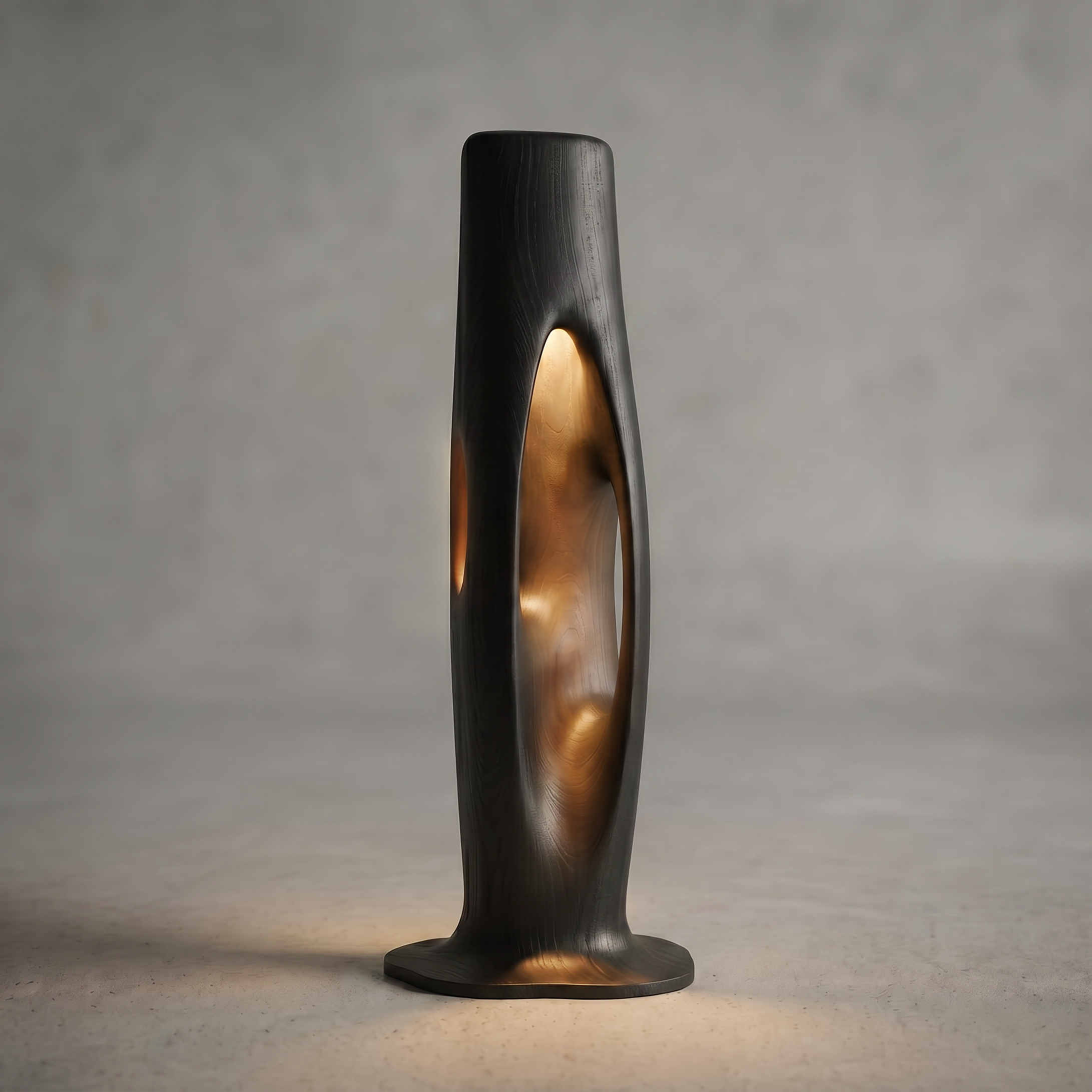 Close-up of a black and gold metallic object with an elongated, curved shape, placed on a white surface with a plain grey background.