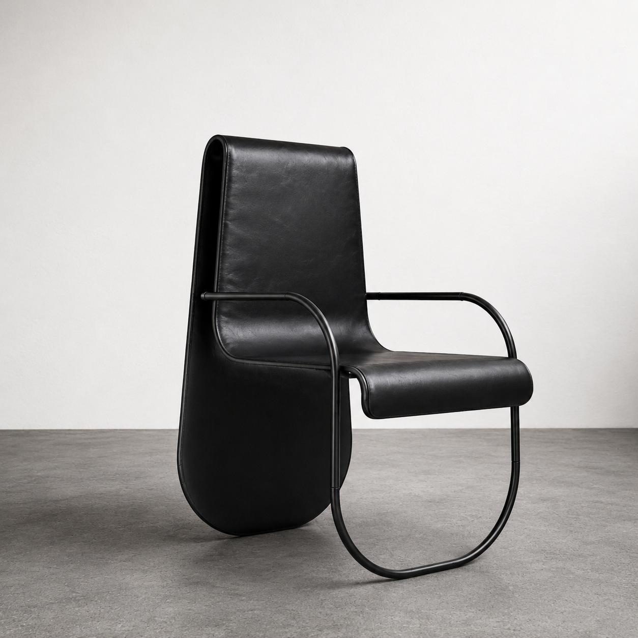 Modern black leather armchair with metal frame against a plain white wall and gray floor.