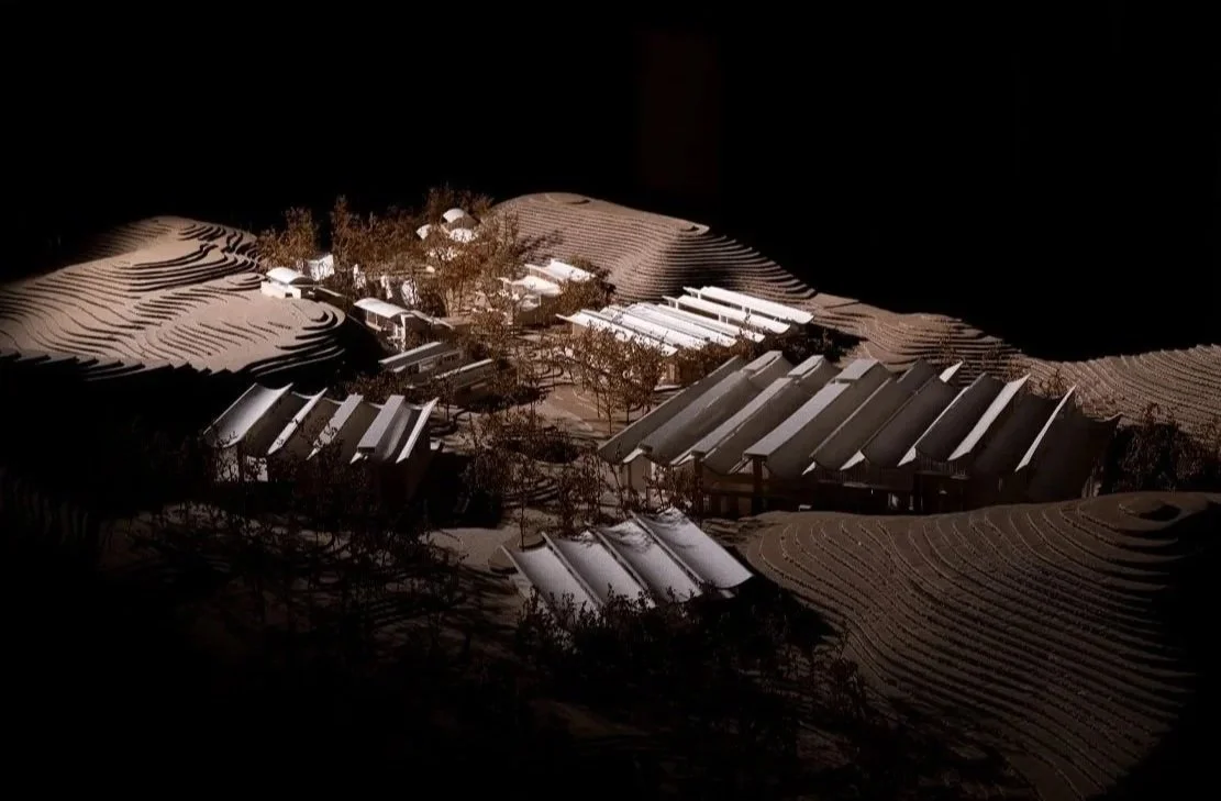 Architectural model of a building complex surrounded by terrain with trees