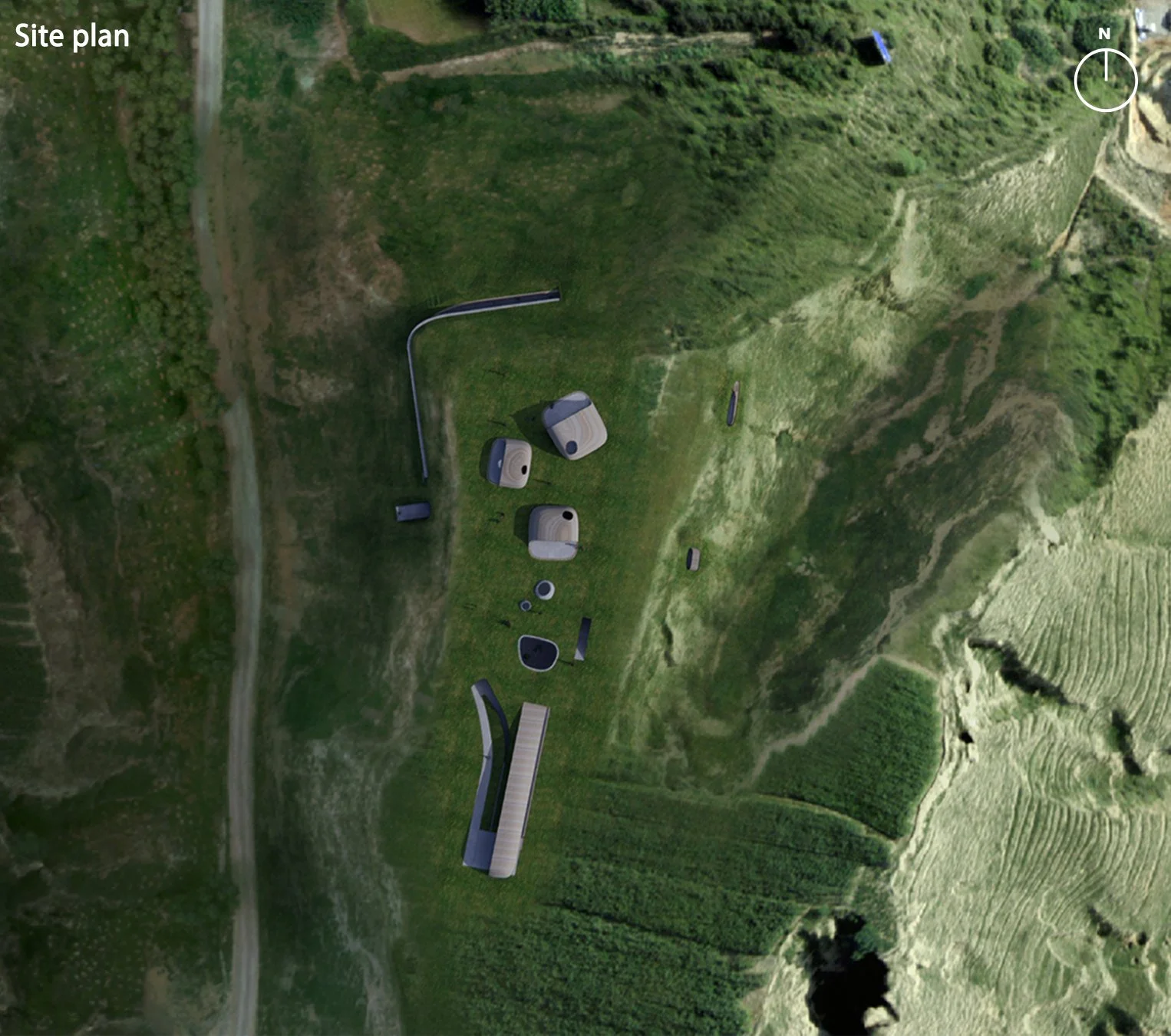 Aerial view of a landscape with scattered modern structures, pathways, and green terrain, labeled as a site plan.