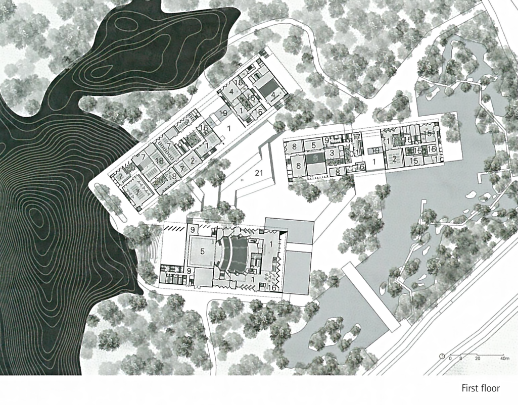 Architectural floor plan of a building complex with multiple structures, surrounded by trees and water features.