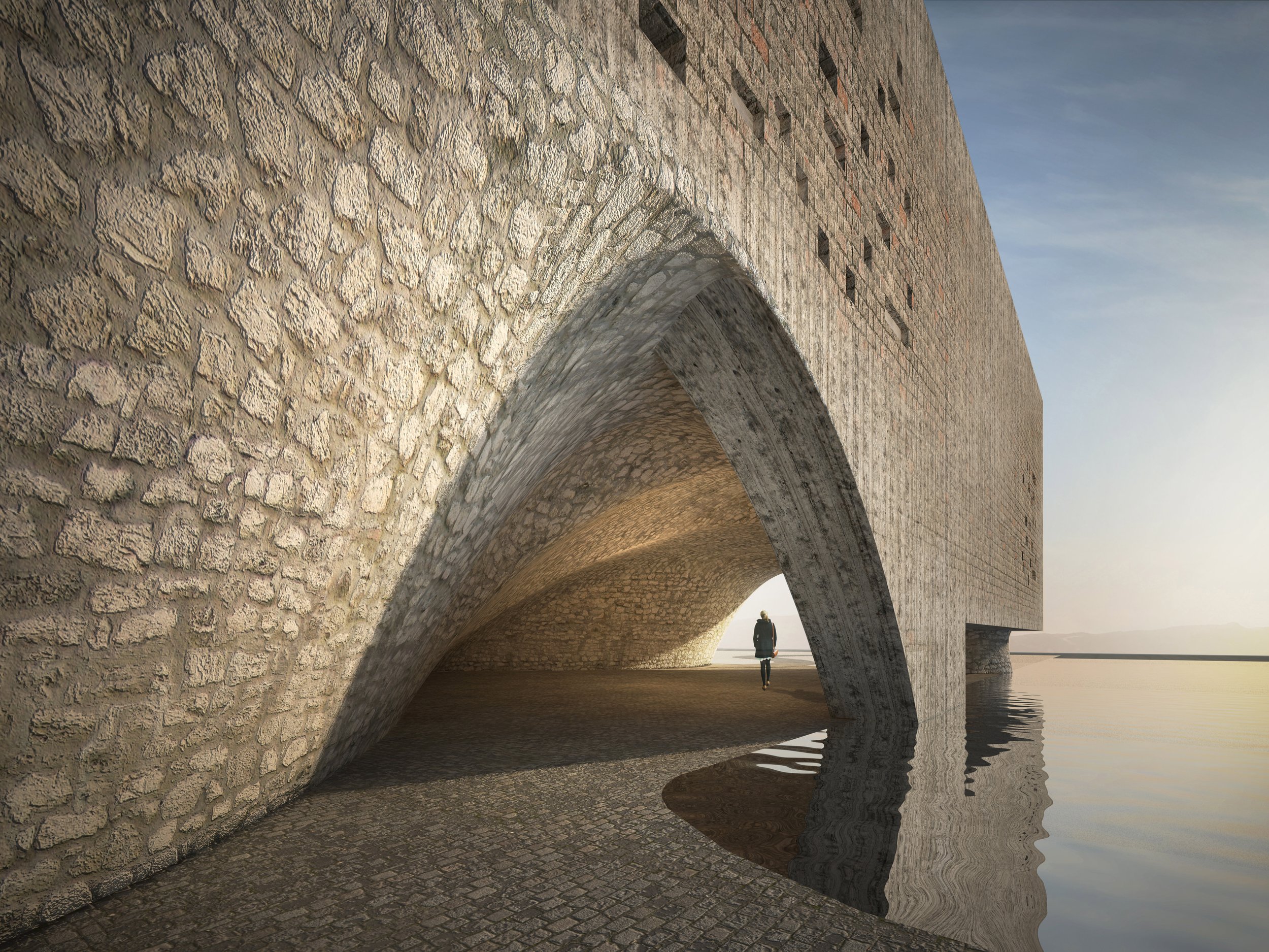 A person walking under a large stone bridge with arches, near water.