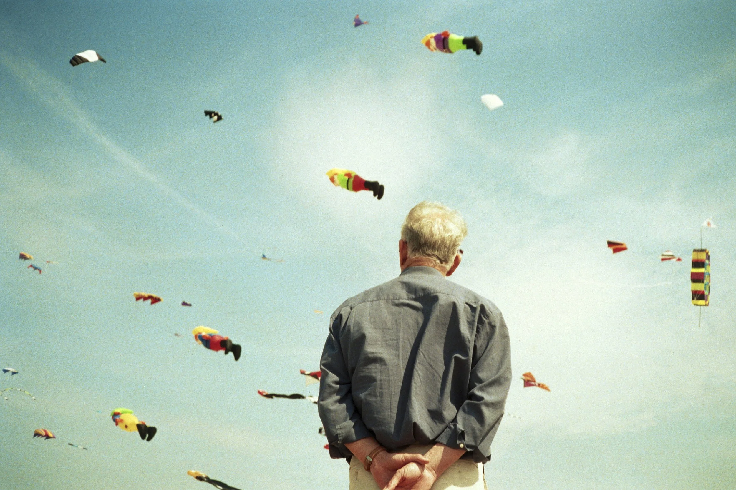 foto van man die kijkt naar vliegers in de lucht