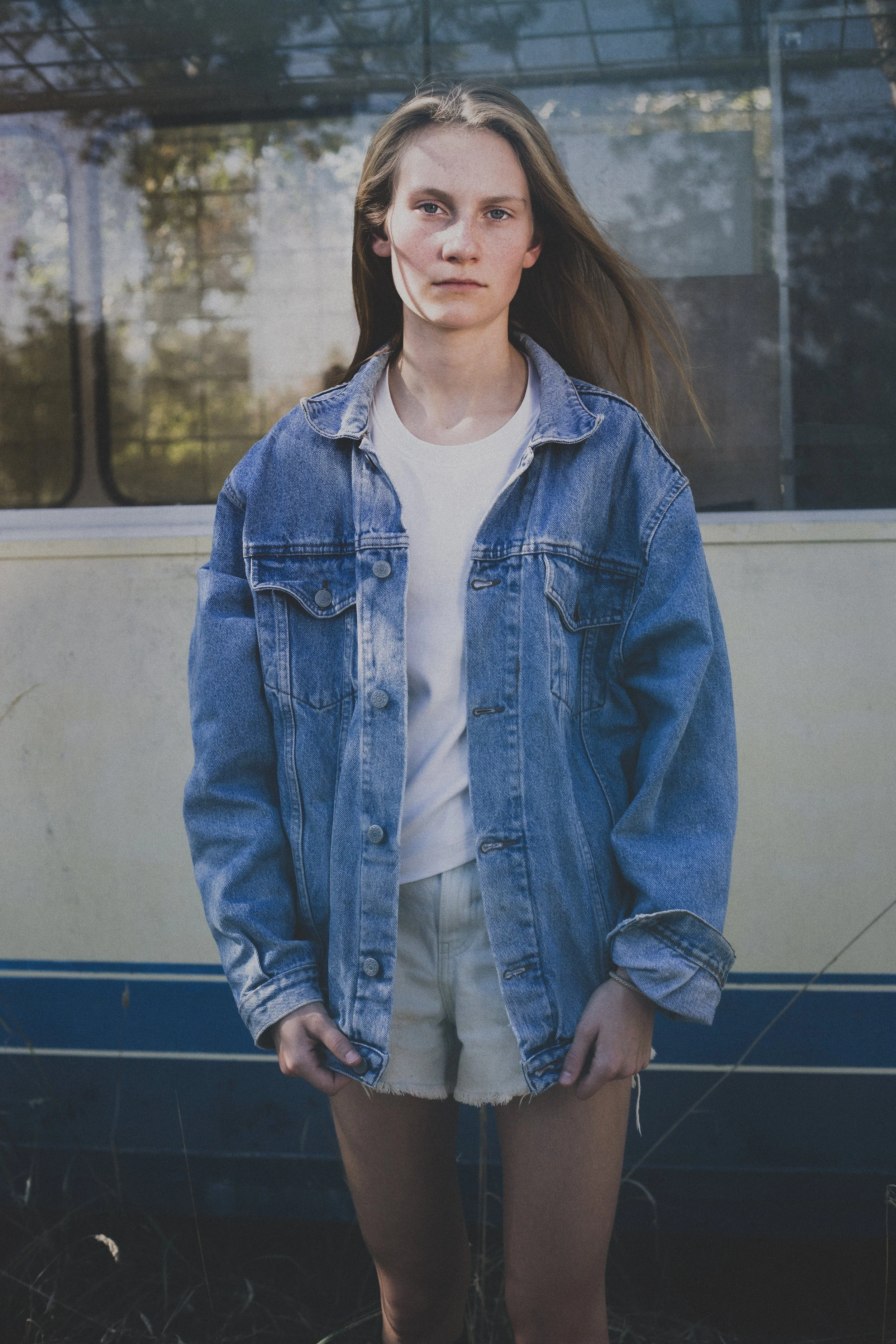 model met haar in de wind gestyled in jeans voor portfolioshoot