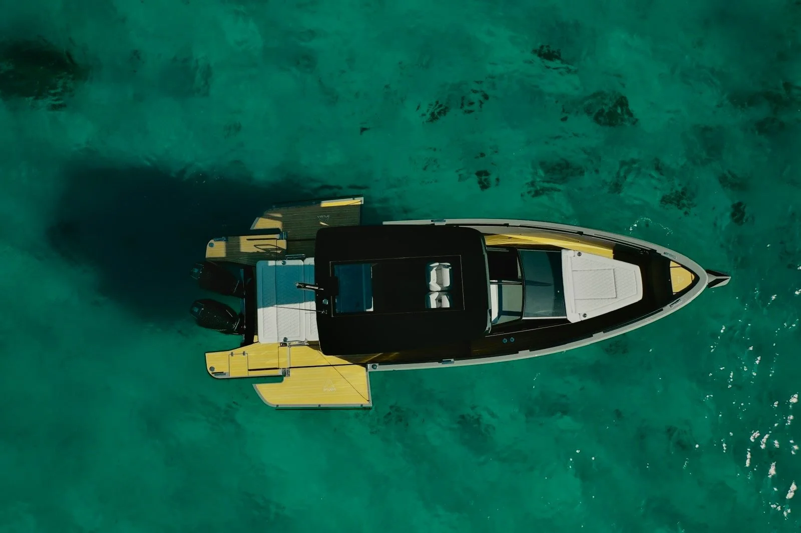 Immagine di una barca moderna vista dall'alto in acqua cristallina verde con motori potenti