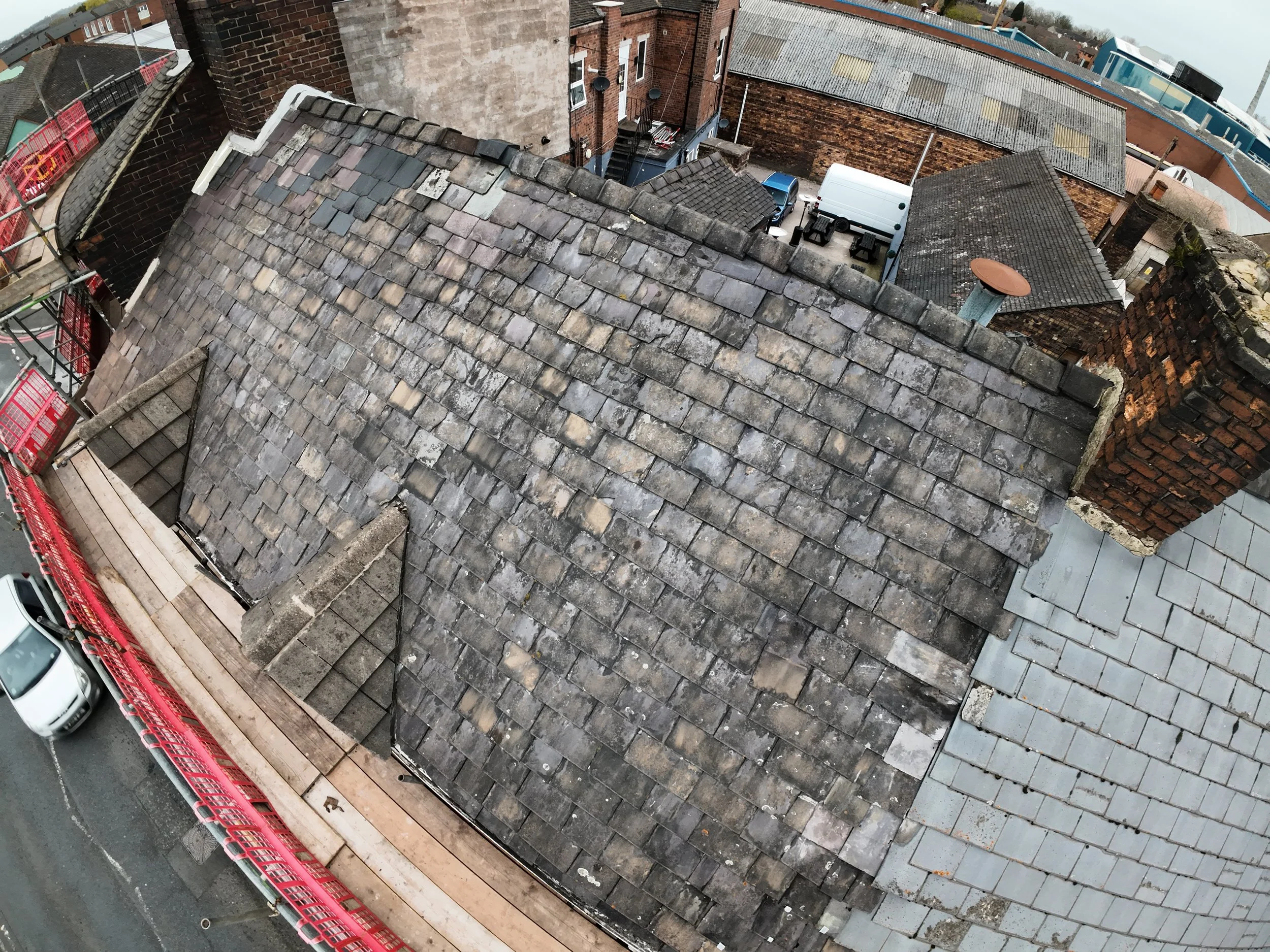 Drone roof inspection showing damaged and mismatched roof tiles for property surveys and maintenance reporting