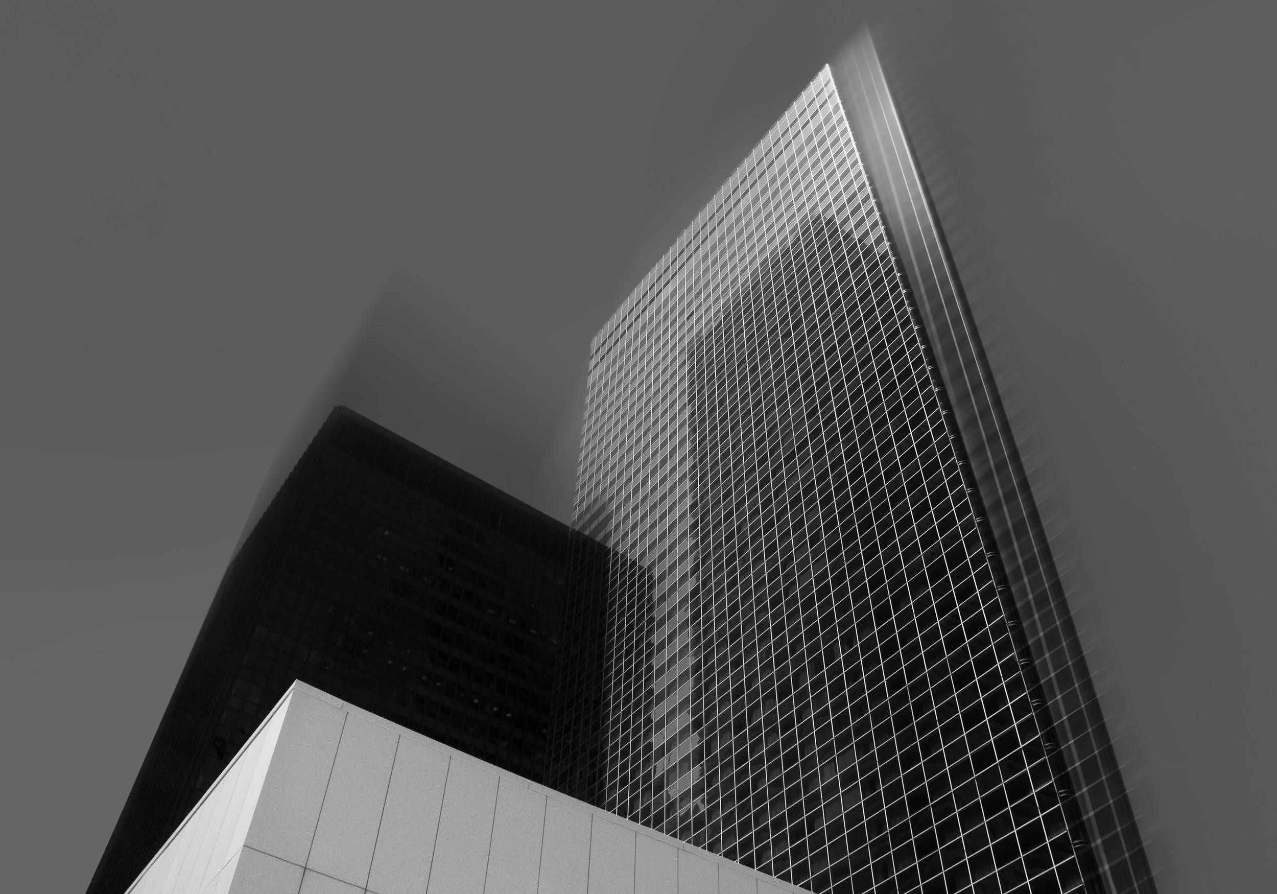 Low-angle view of modern skyscrapers with glass facades against a clear sky.