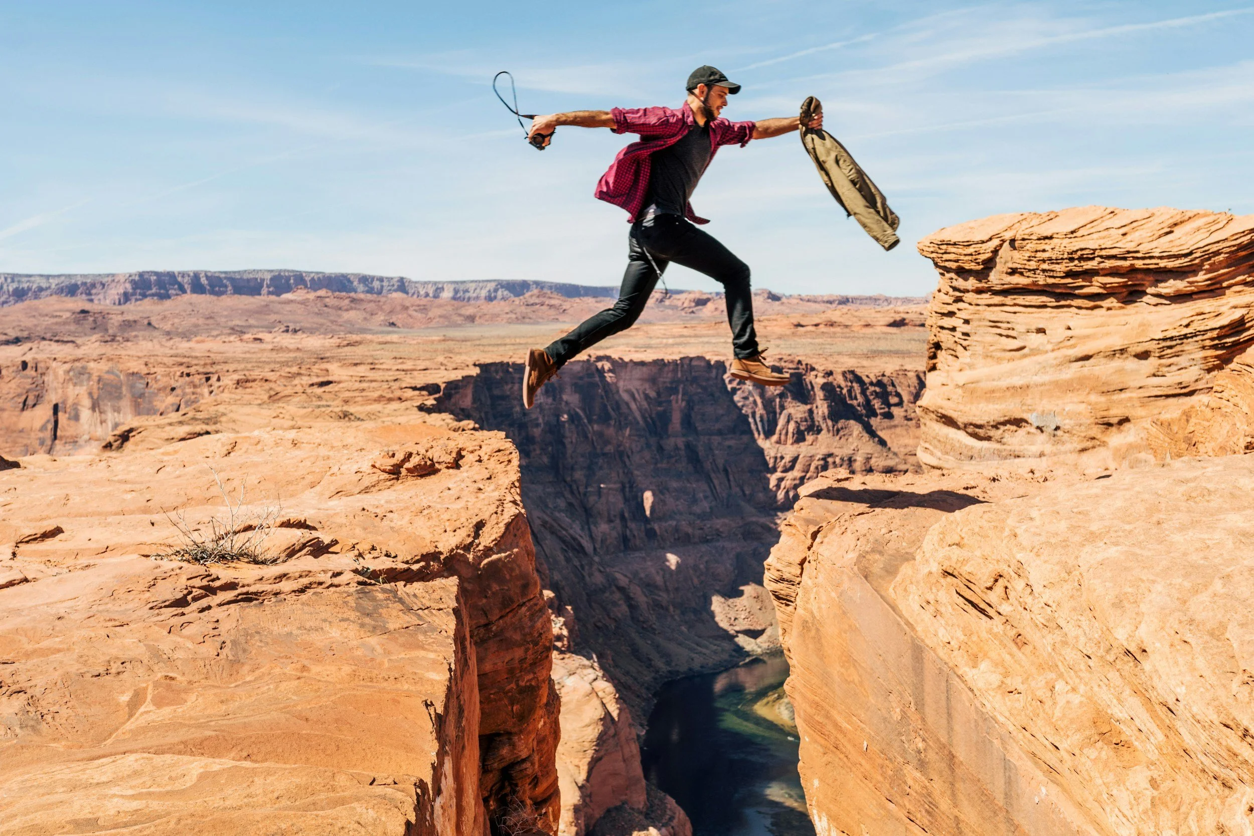 Person leaping across a canyon, symbolising progress, courage and the journey towards financial freedom.
