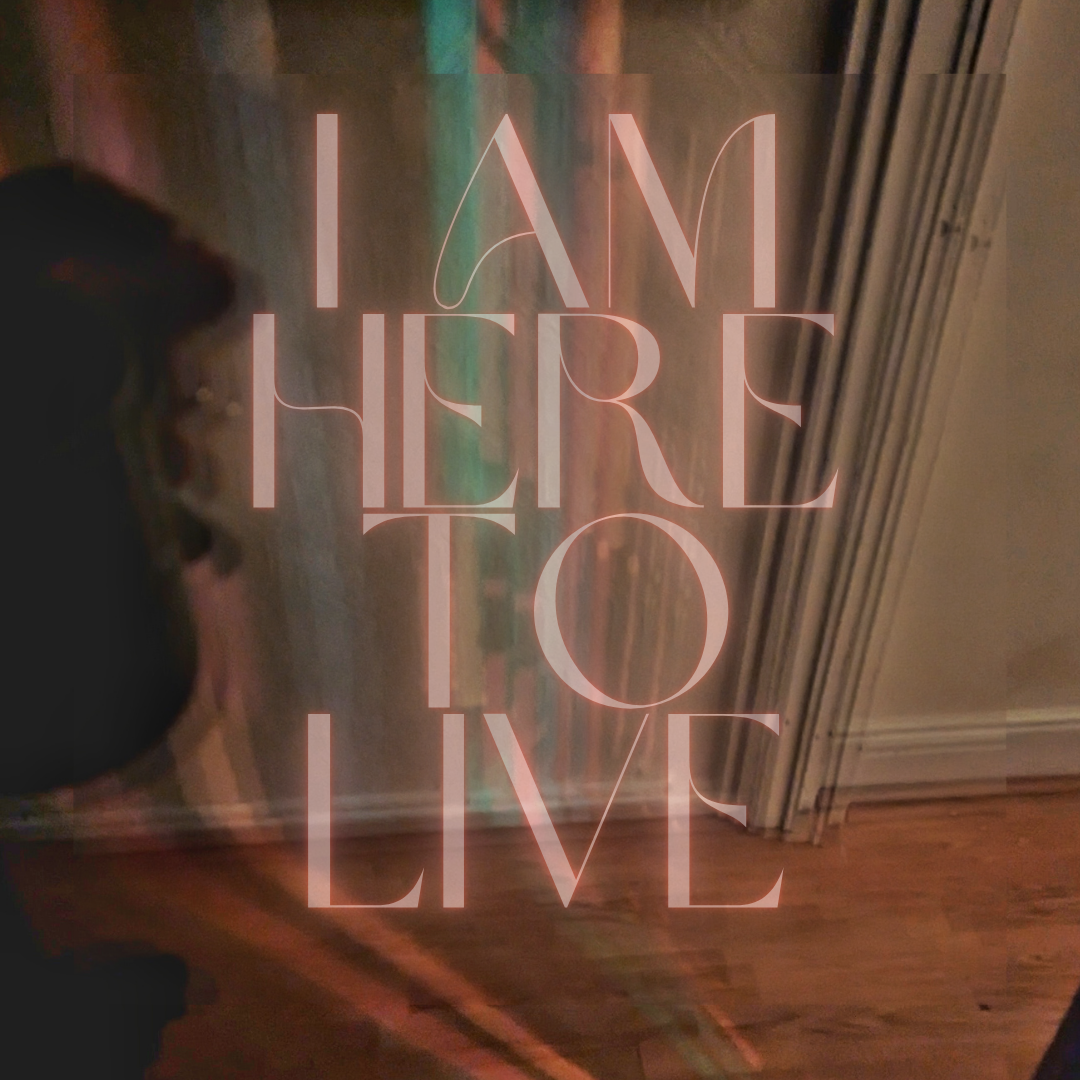 Decorative glass door with the phrase "I am here to live" written in pink uppercase letters.
