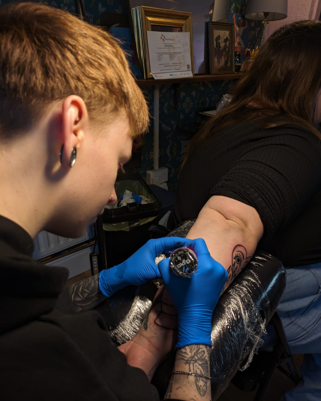 chloe tattooing a clients arm