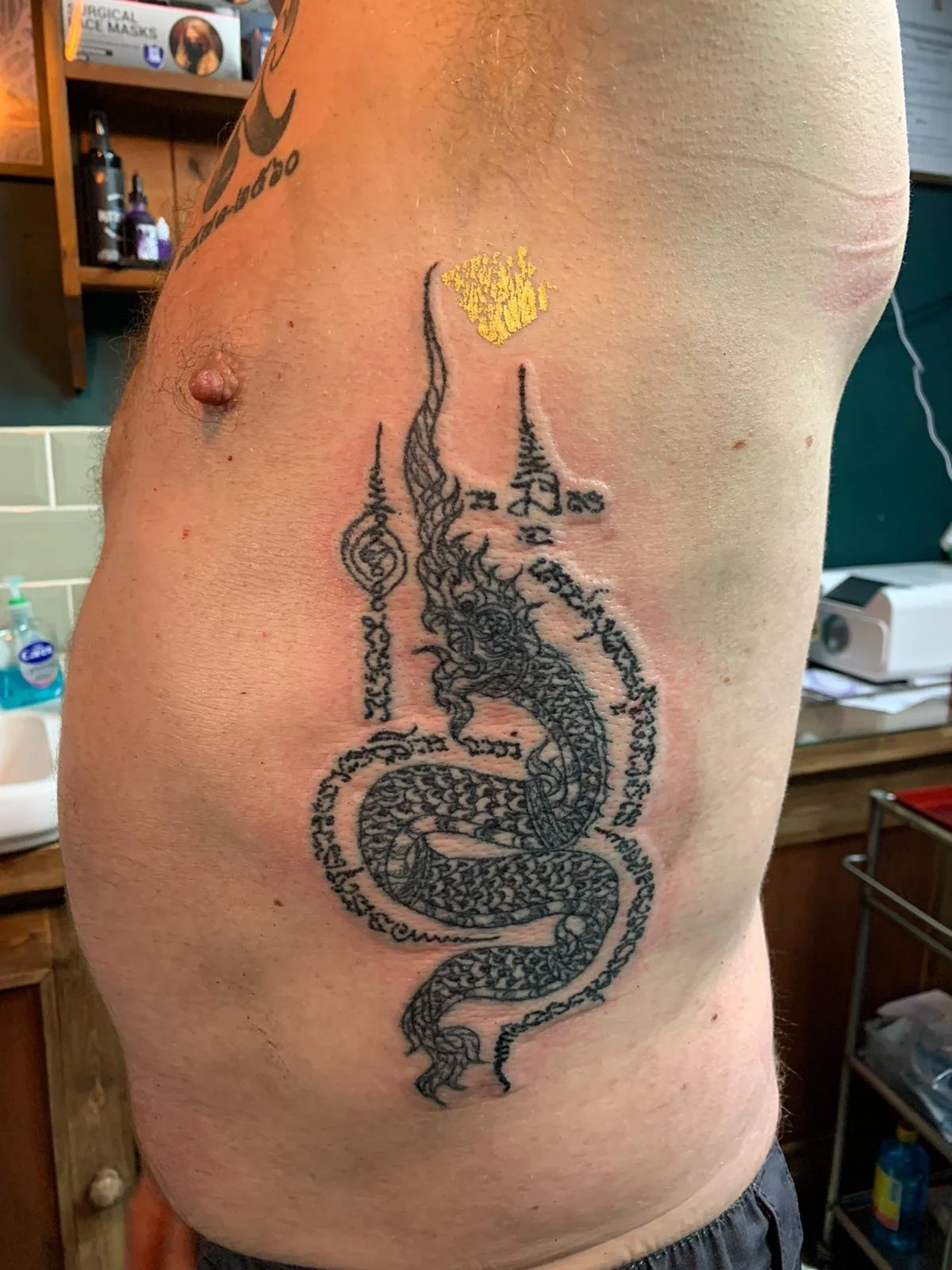 sak yant thai tattoo dragon design on ribs