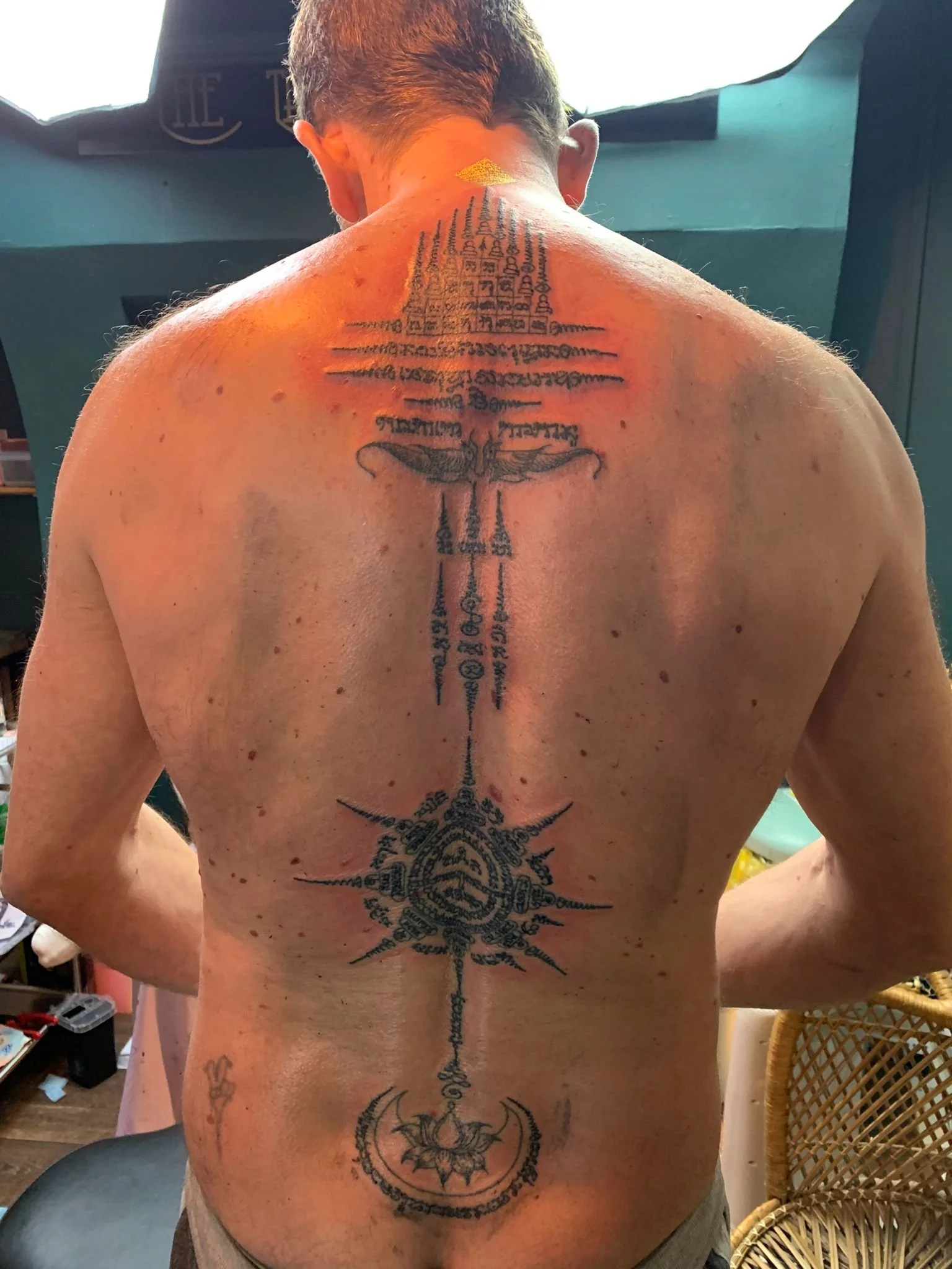 sak yant thai tattoo down spine on back