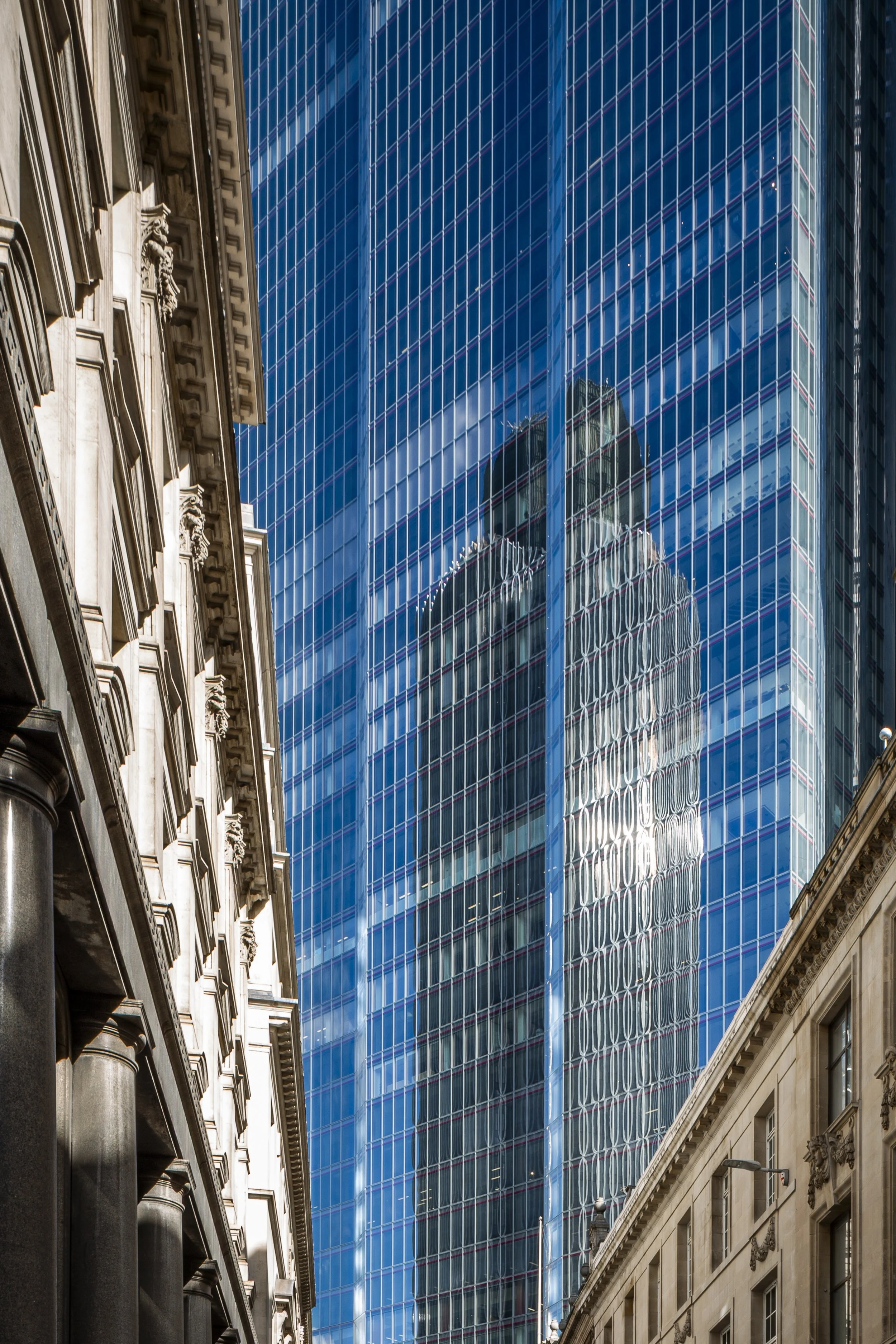 A view of the historical buildings on Threadneedle Street with a view towards the huge glass tower TwentyTwo on Bishopsgate. A contrast of Victorian London and modern skyscapers. Tower 42 ios also reflected in the glass. Shot with a shift lens to kee