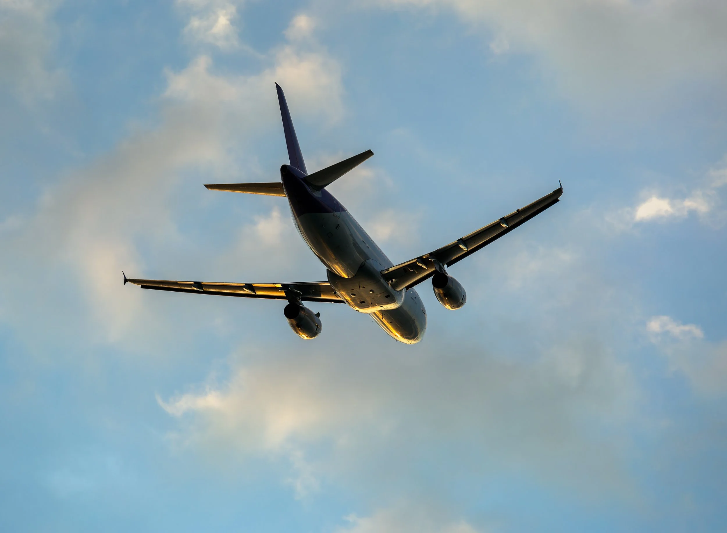 Aircraft flying in the sky with clouds.