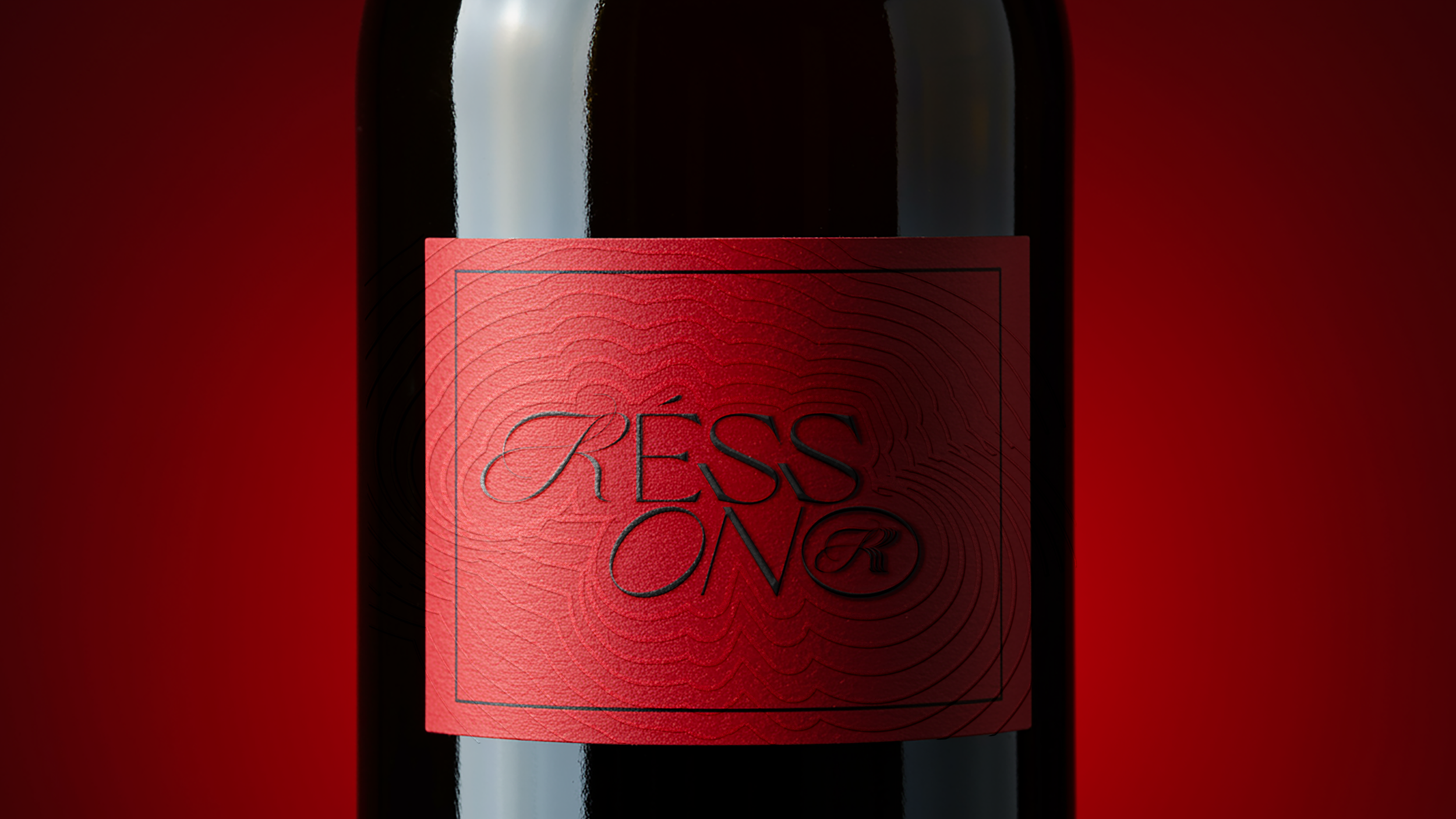 A close-up of a dark wine bottle with a red textured label that says 'RESSON' in black text.
