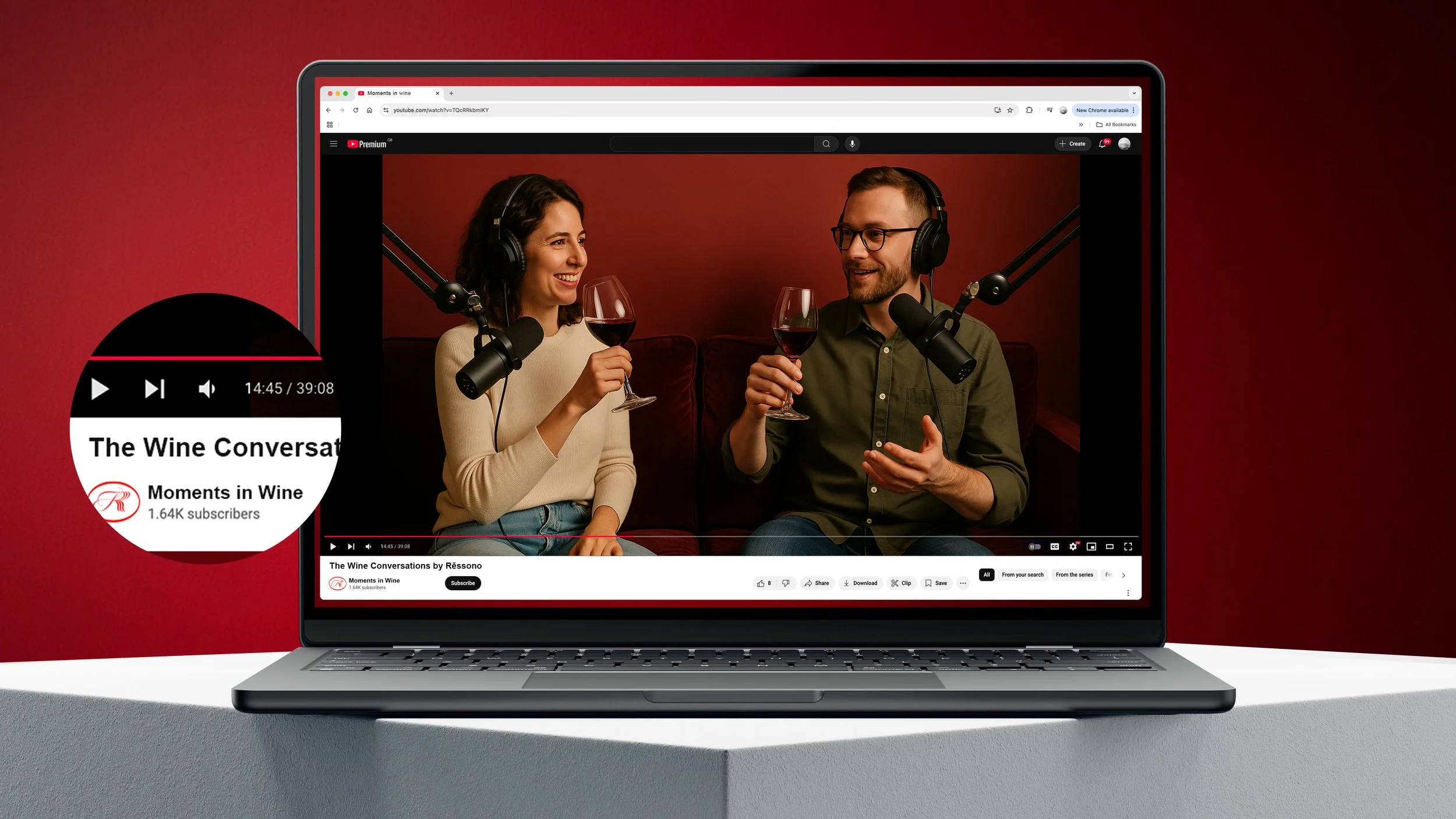 A laptop displaying a YouTube video titled 'The Wine Conversations' by 'Moments in Wine' featuring a woman and a man wearing headphones, holding glasses of red wine, and talking with microphones in front of them.