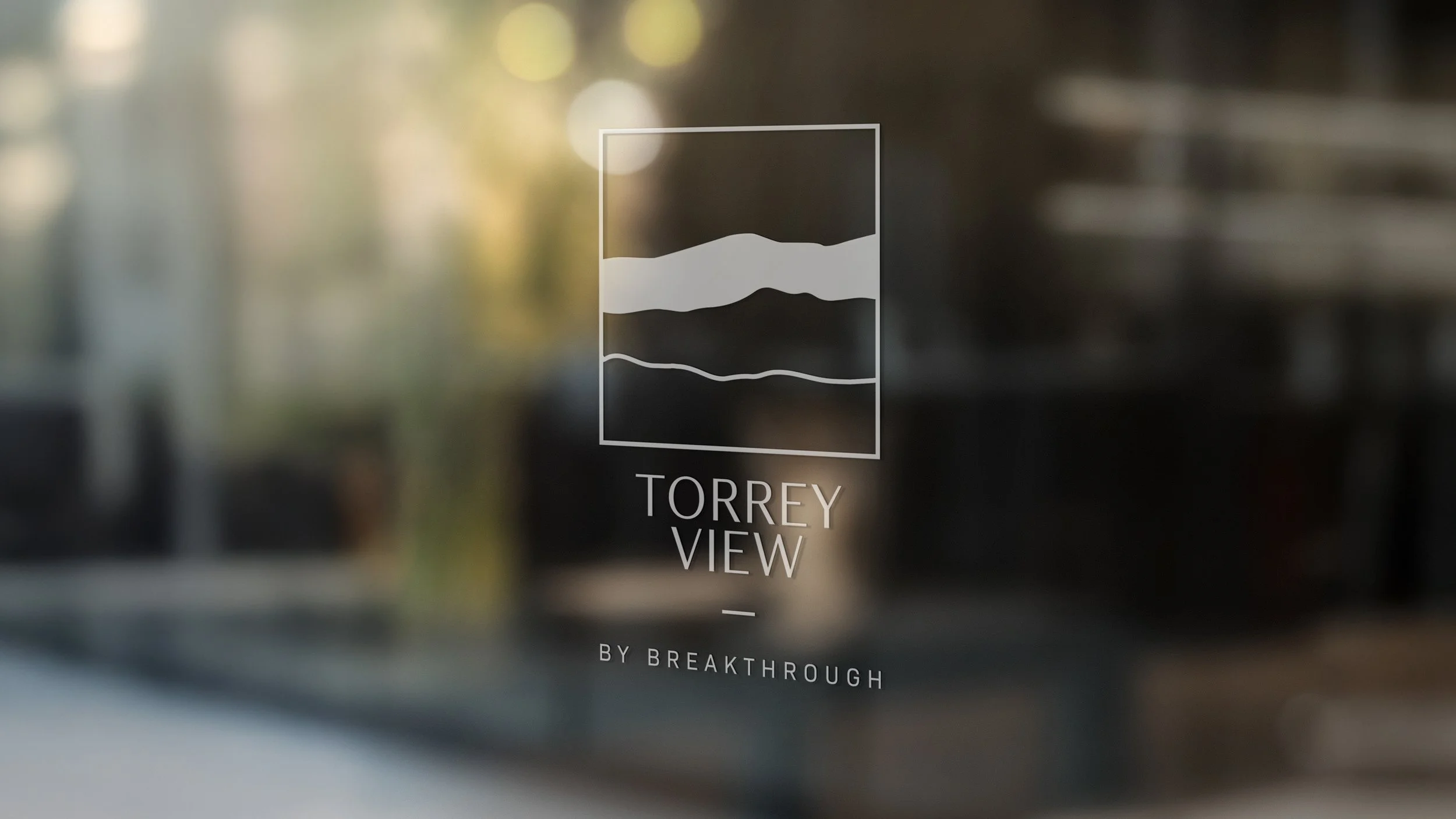 Glass door window with the text 'Torrey View by Breakthrough' and a stylized mountain landscape logo.