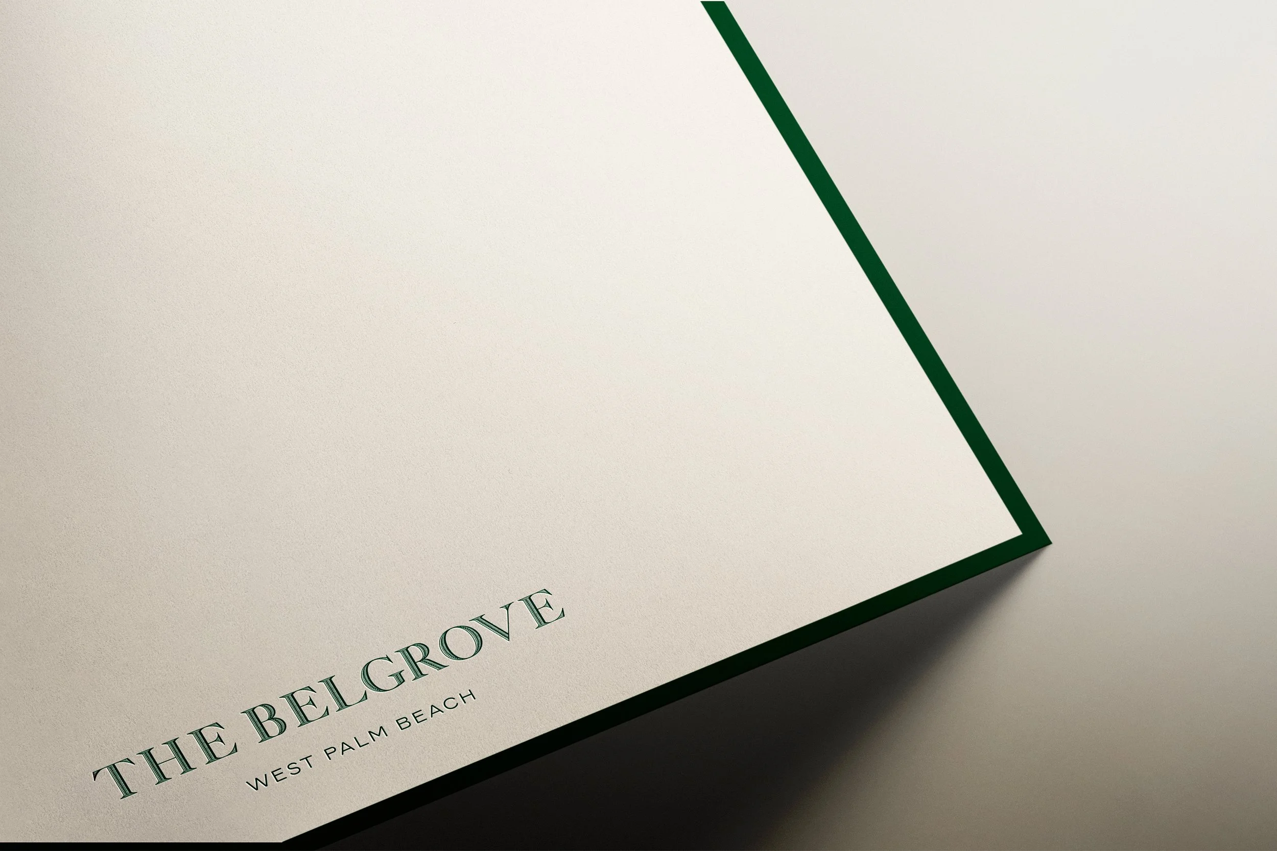 A close-up of a white paper with green border edges, featuring the text 'THE BELGROVE' and 'WEST PALM BEACH' printed in green.