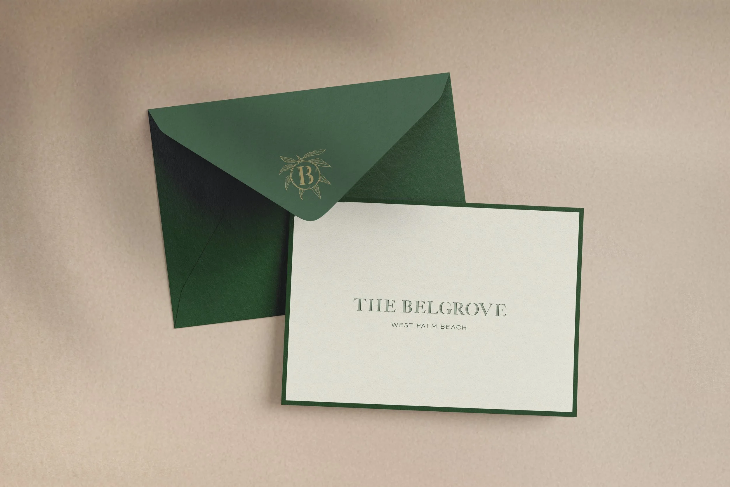 Green envelope with gold emblem containing the letter 'B' and a card with the text 'The BelGrove, West Palm Beach'.