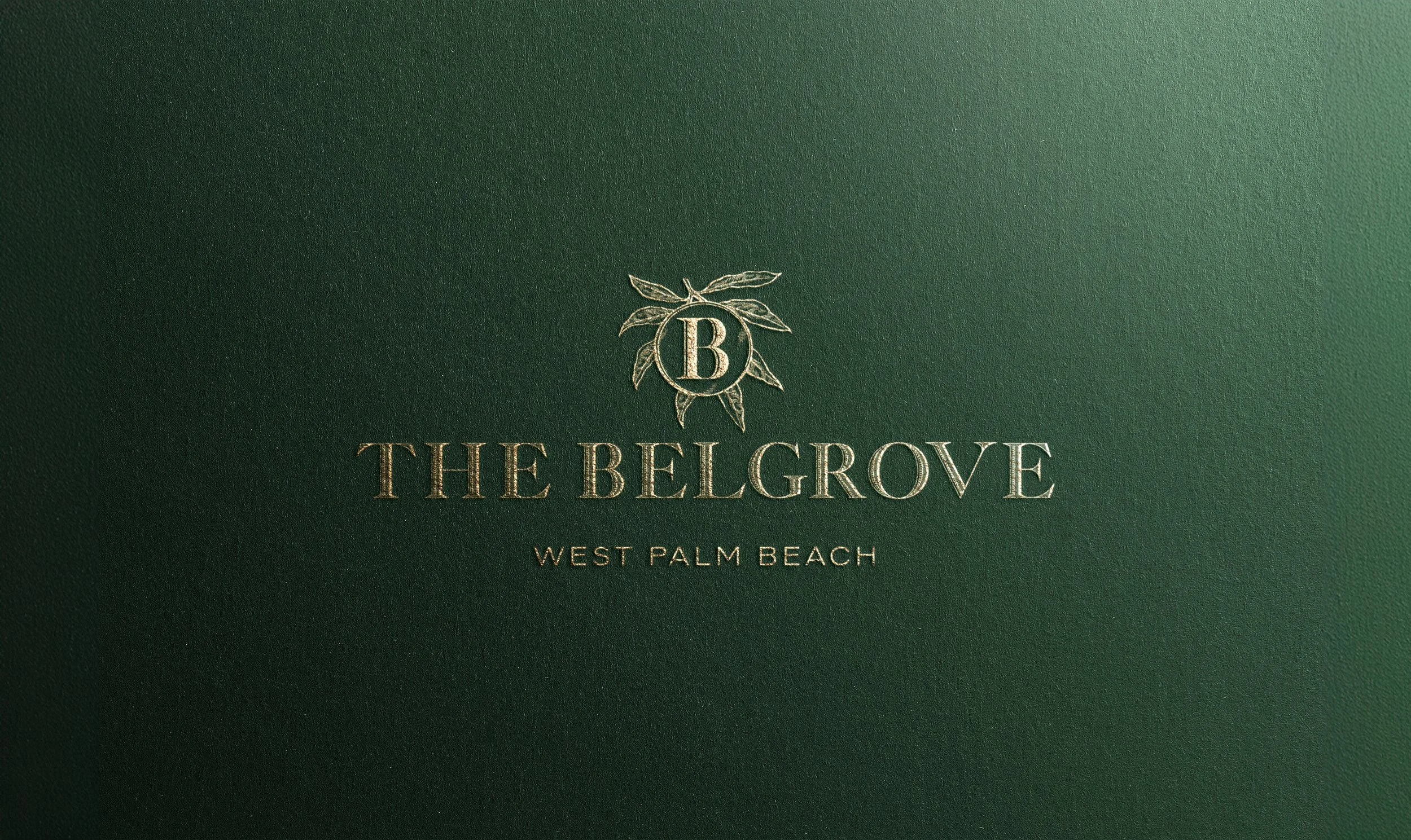 Green textured background with gold embossed text and emblem. The emblem has a circle with a letter 'B' surrounded by a floral design. The text reads 'THE BELGROVE' and underneath 'WEST PALM BEACH'.