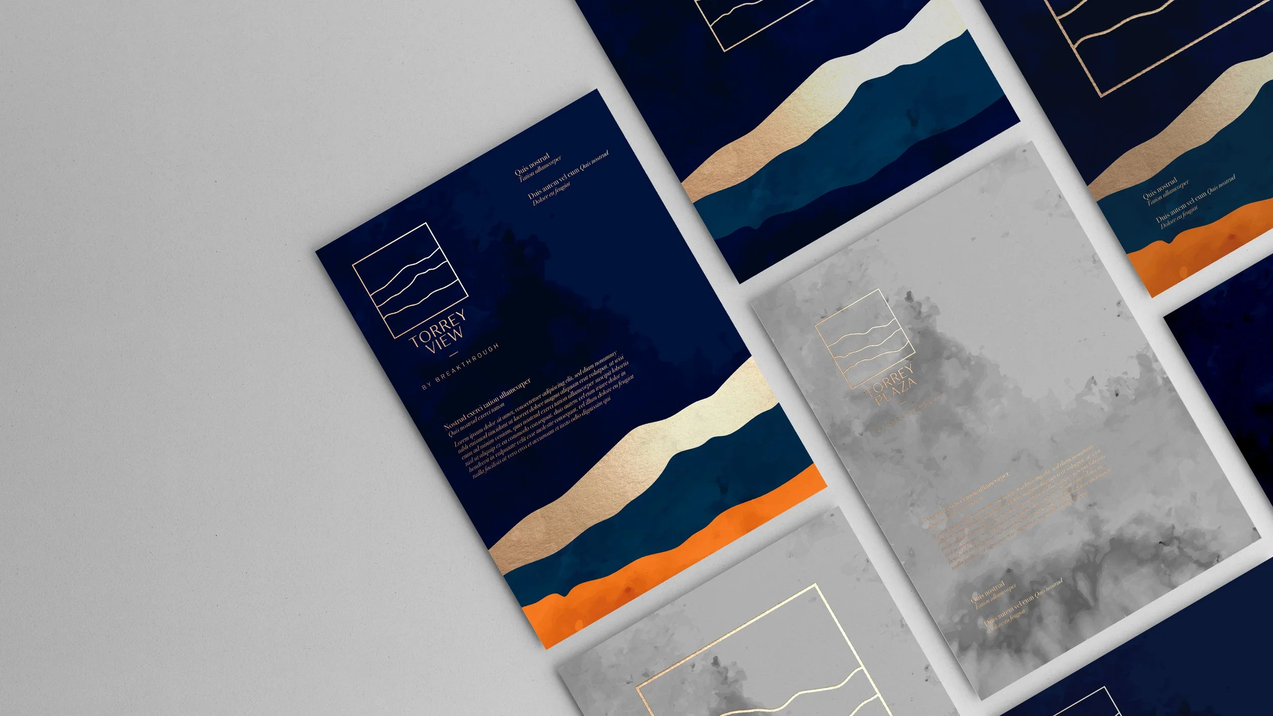 Multiple brochures with abstract mountain landscape designs in navy blue, gray, orange, and cream colors.