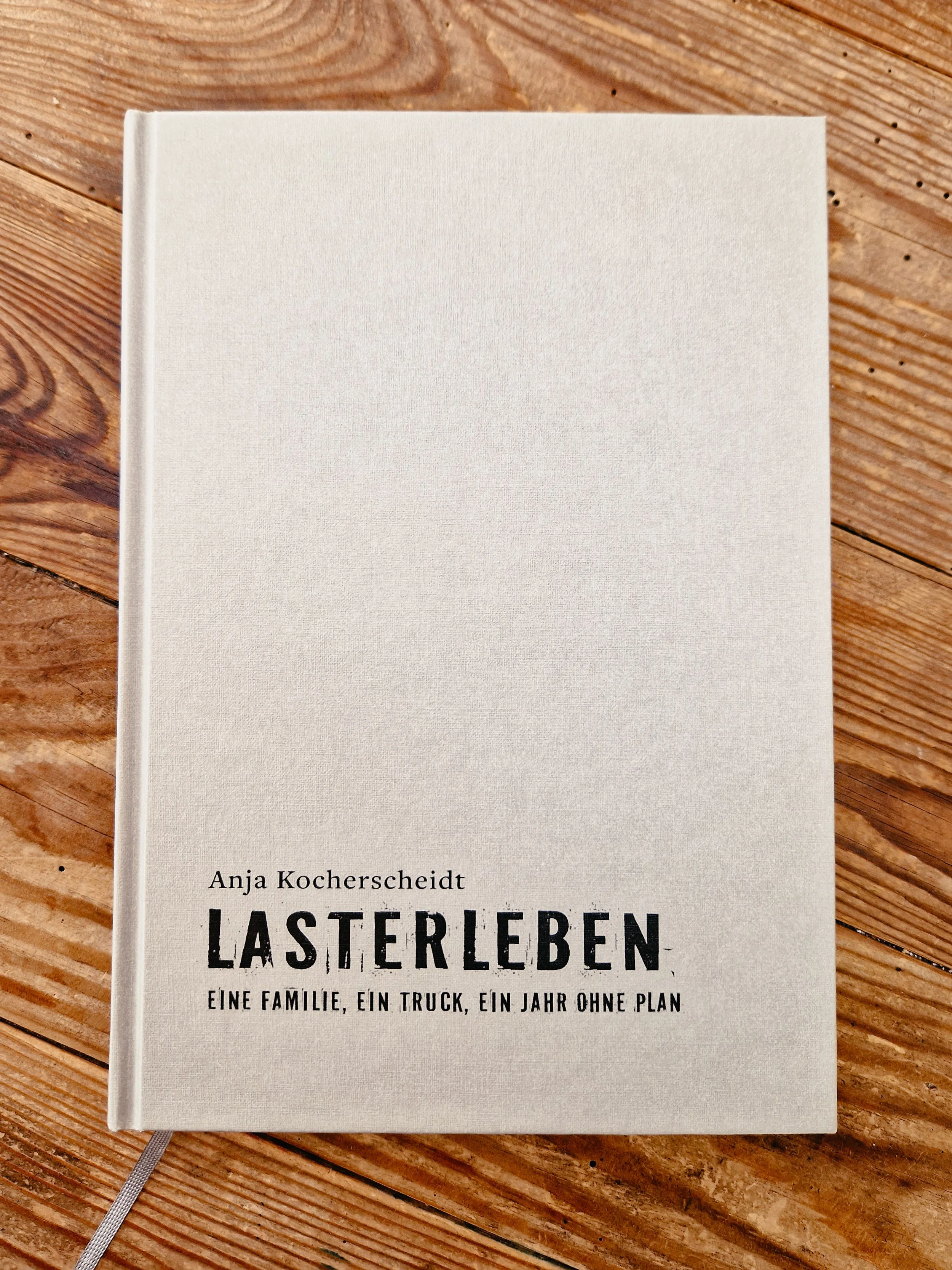 Ein Buchdeckel mit dem Titel 'LASTERLEBEN' von Anja Kocherscheidt auf einem Holztisch.