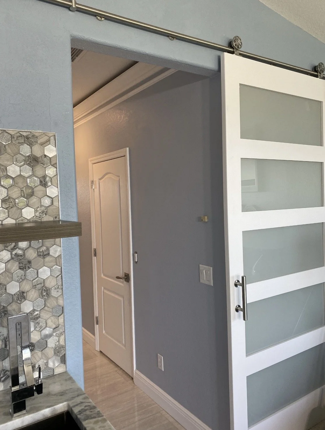 See-through sliding door with frosted glass panels on a wall.